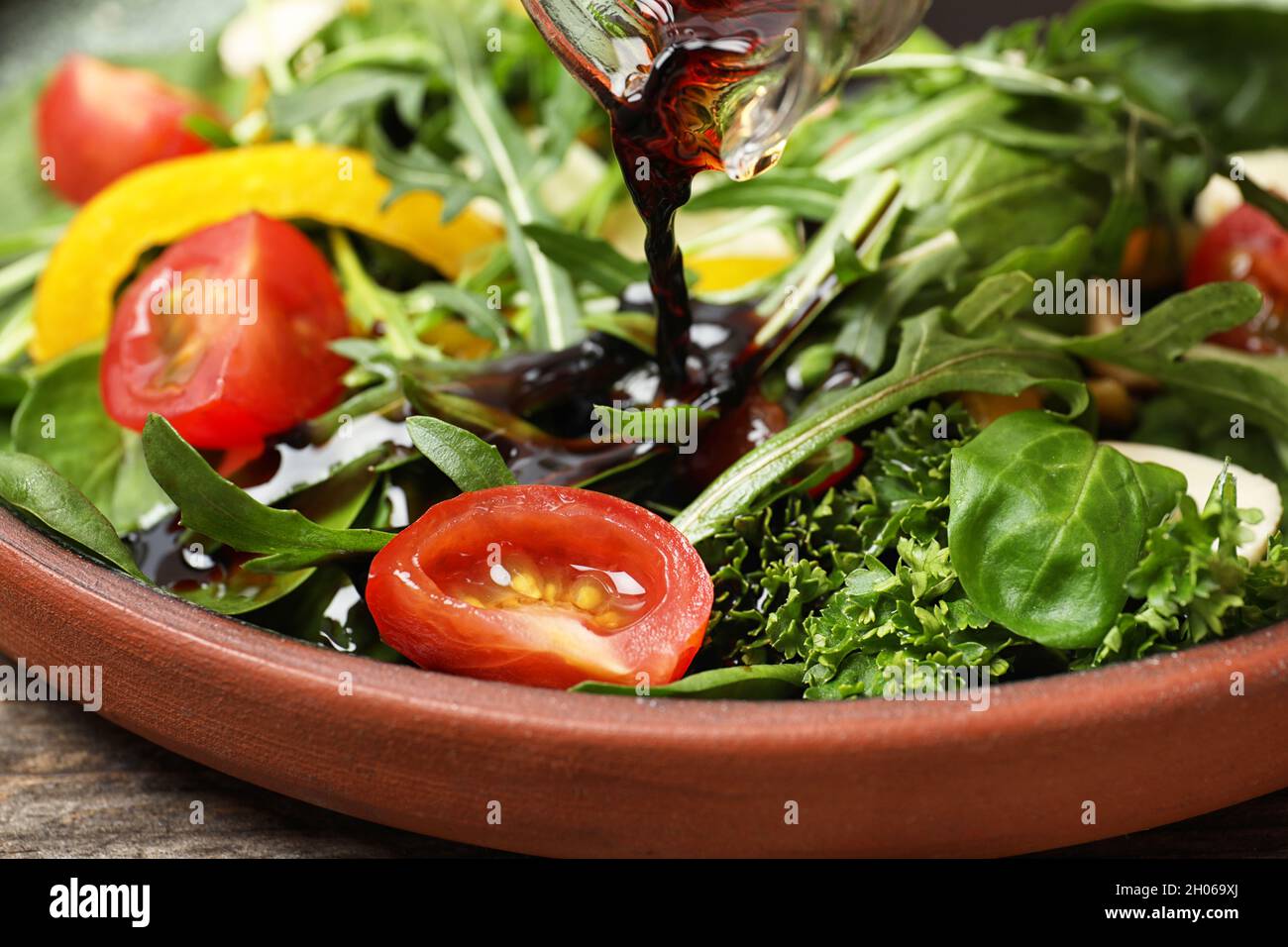 Verter vinagre balsámico en ensalada de verduras frescas en el plato,  closeup Fotografía de stock - Alamy