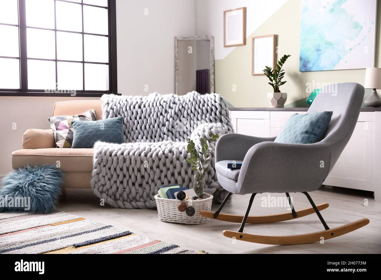 Elegante sala de estar interior con un cómodo sofá y una mecedora  Fotografía de stock - Alamy