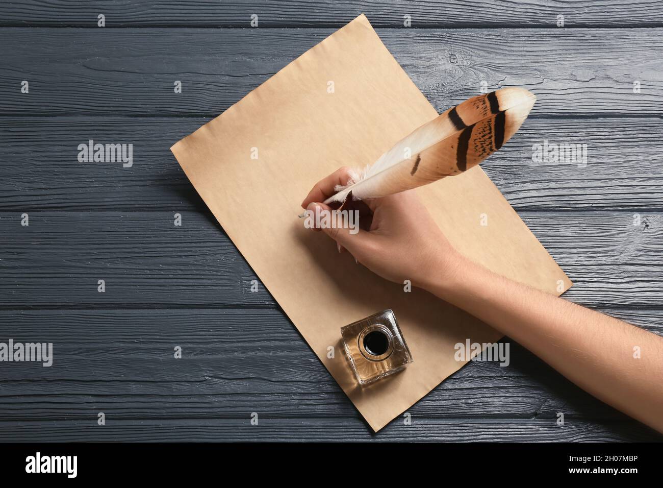 Mujer usando pluma para escribir con tinta sobre pergamino en mesa de  madera, vista superior. Espacio para texto Fotografía de stock - Alamy