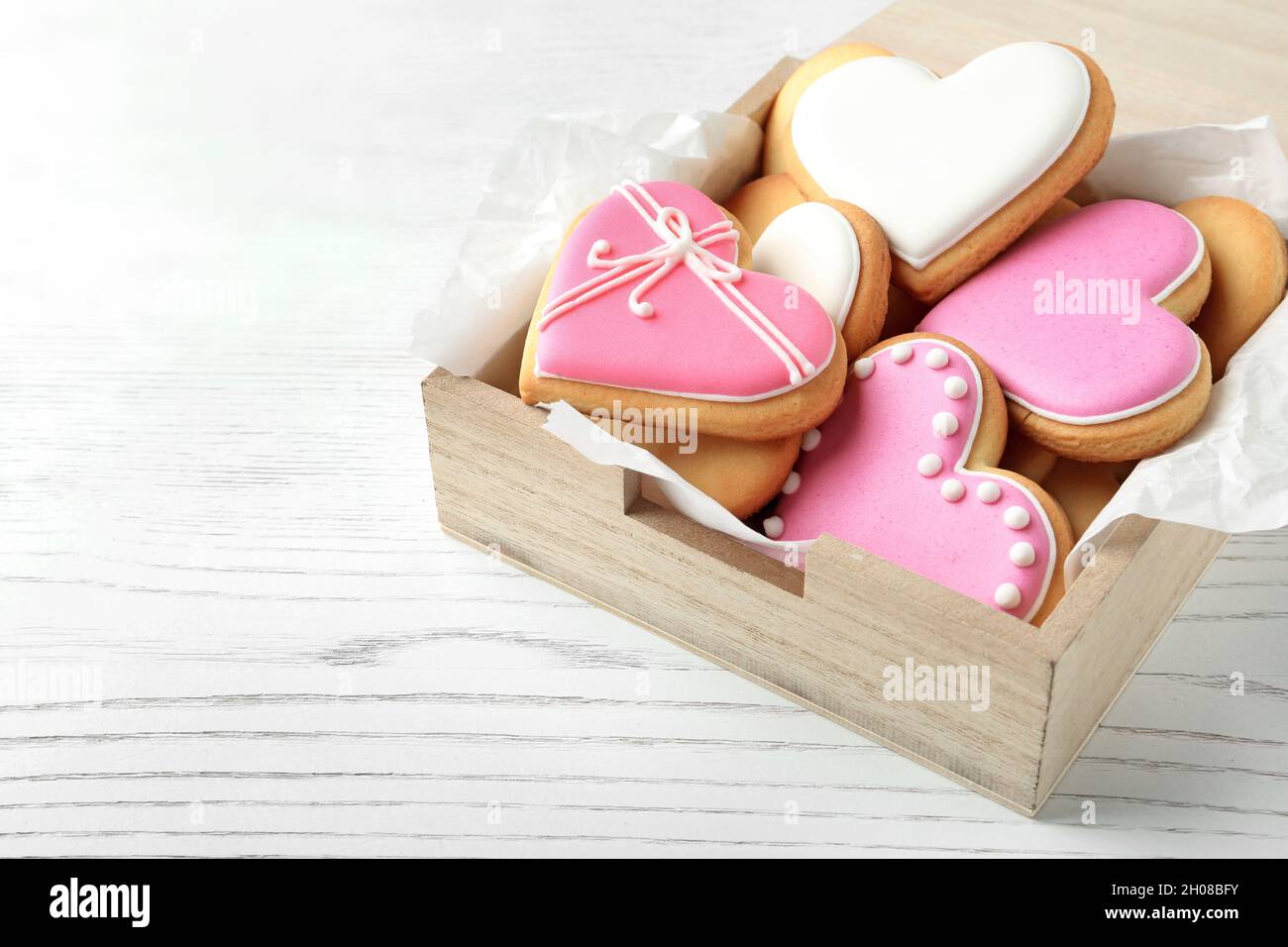 Galletas decoradas en forma de corazón en una caja de madera sobre la mesa.  Espacio para texto Fotografía de stock - Alamy
