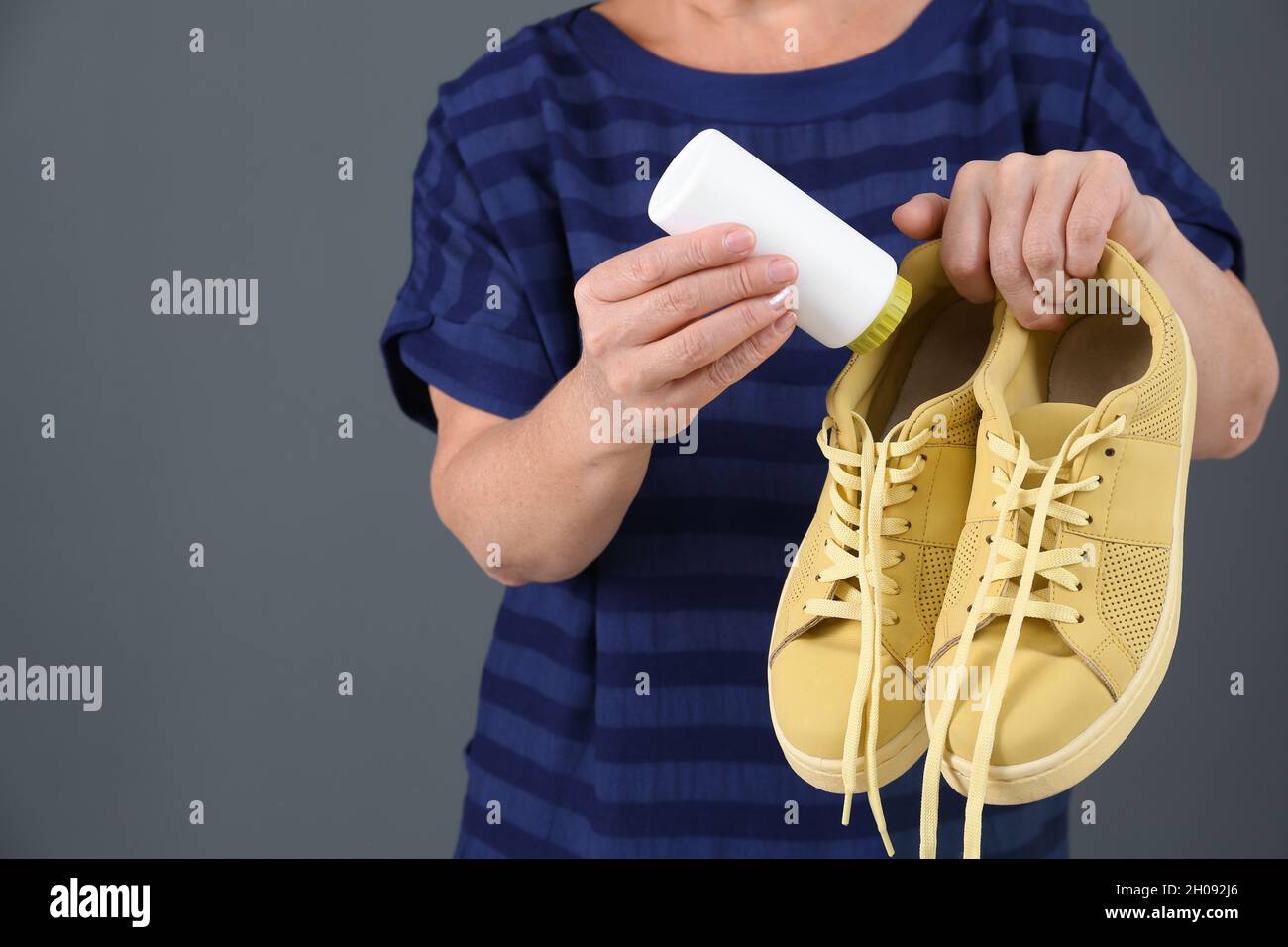 Mujer poniendo ambientador de zapatos en polvo en el calzado sobre fondo de  color, primer plano Fotografía de stock - Alamy