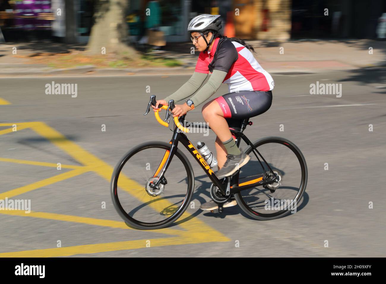 Una ciclista femenina que monta una bicicleta de carreras en Chiswick High Road, Londres, Reino Unido Foto de stock