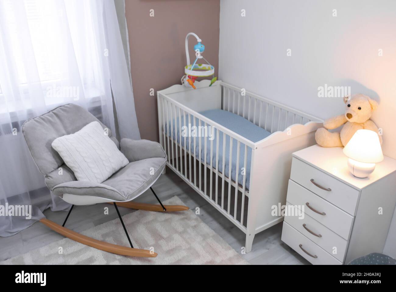 Acogedor de la habitación del bebé con cuna y mecedora Fotografía de stock - Alamy