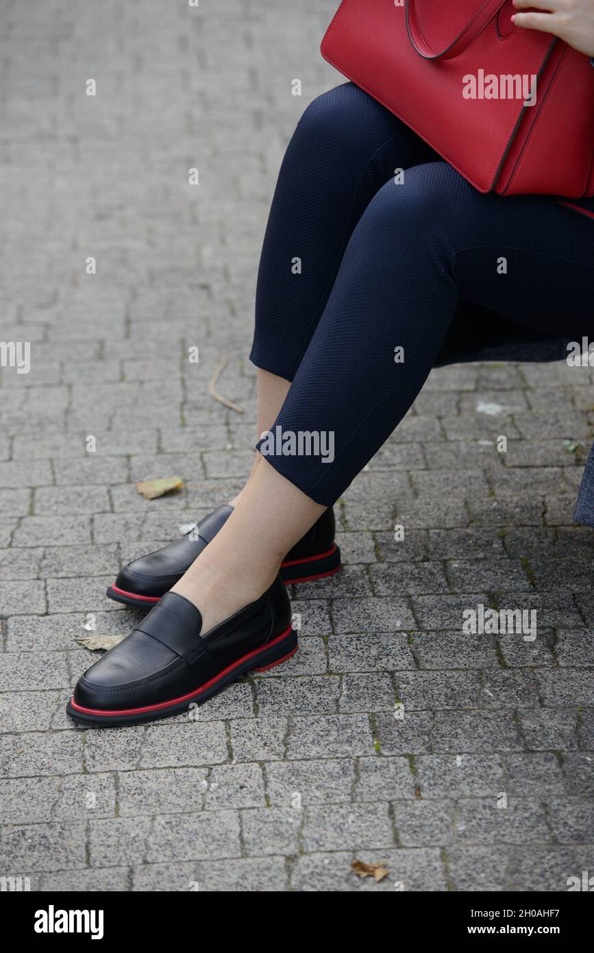 Concepto de moda femenina. Las piernas de las mujeres en zapatos negros con  línea roja Fotografía de stock - Alamy