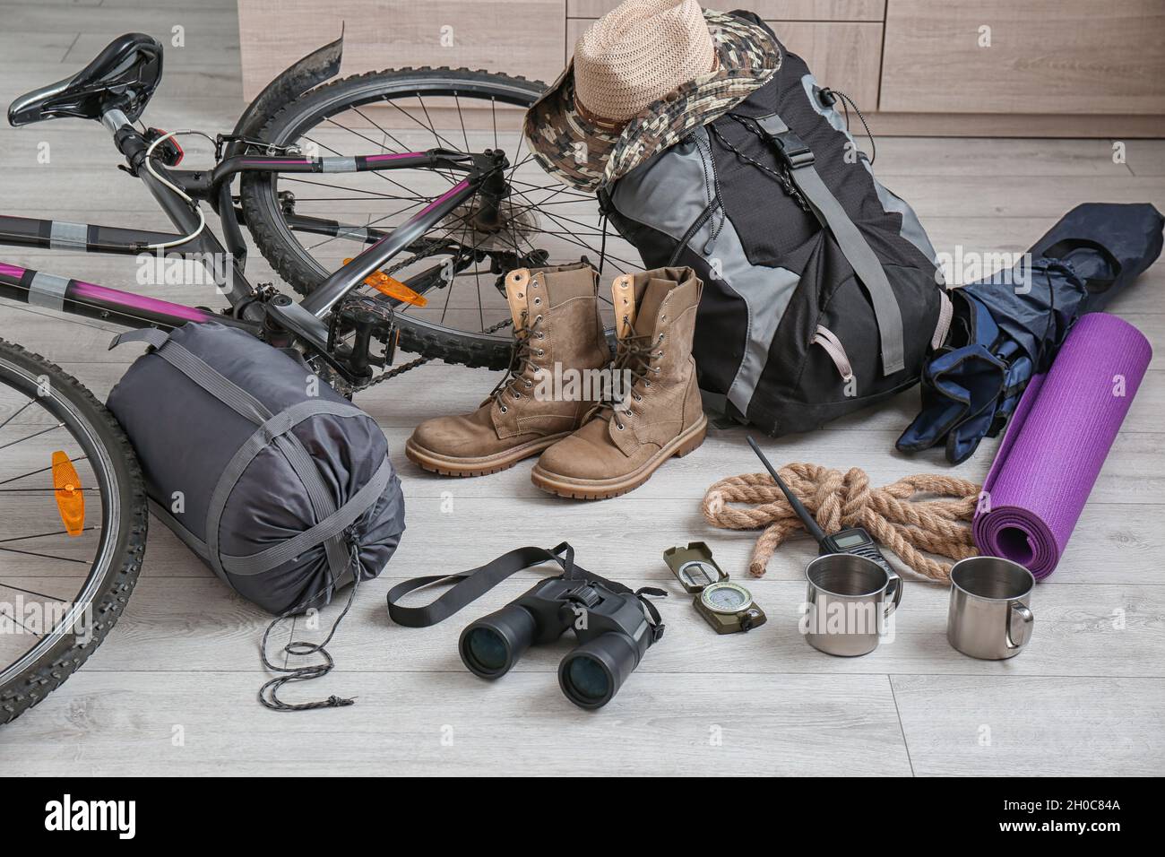 Saco de dormir, bicicleta y equipo de camping en suelo de madera Fotografía  de stock - Alamy