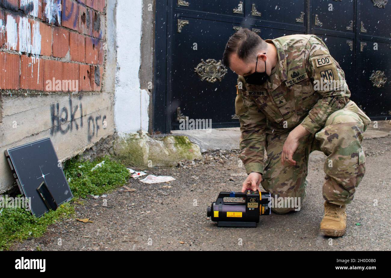 SGT. Mark Henderson, soldado del equipo de eliminación de artefactos explosivos adscrito al Comando Regional Este de la Fuerza de Kosovo, prueba un sistema de rayos X durante una llamada de emergencia de la AOD en Gjilan/Gnjilane, Kosovo, el 27 de enero de 2021. Henderson utilizó los rayos X para determinar si los artefactos explosivos eran seguros para ser movidos. La 702nd Ordnance Company, con sede en Grafenwoehr, Alemania, está apoyando la misión de la KFOR encabezada por la OTAN, dedicada a crear un entorno seguro para todas las personas de Kosovo. Foto de stock