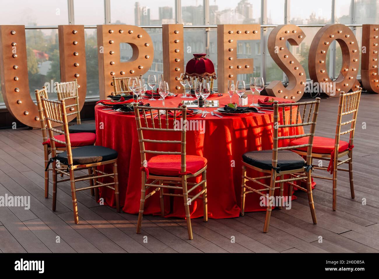 Mesas y sillas para banquetes en estilo negro, rojo y dorado. Elegante  salón de eventos: Decoración, manteles, platos, servilletas, rosas, gafas  Fotografía de stock - Alamy