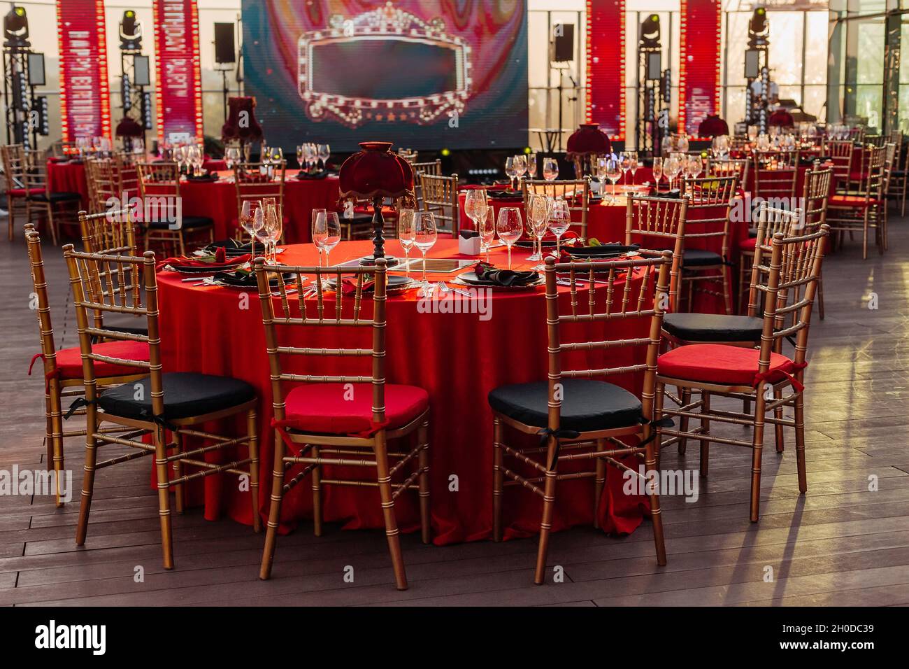 Mesas y sillas para banquetes en estilo negro, rojo y dorado. Elegante  salón de eventos: Decoración, manteles, platos, servilletas, rosas, gafas  Fotografía de stock - Alamy