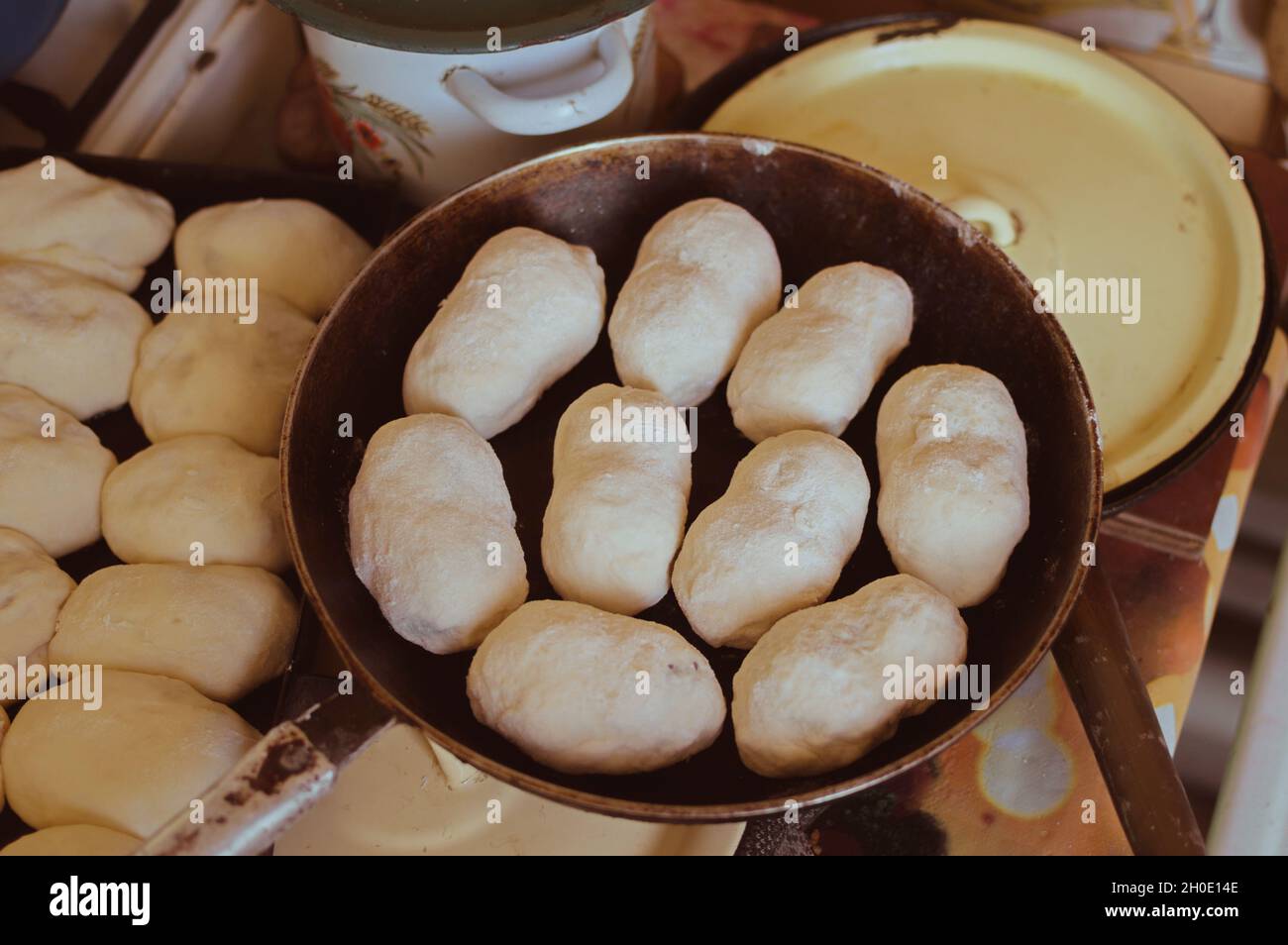Cocinar pasteles con patatas, hileras de pasteles en una hoja de horno