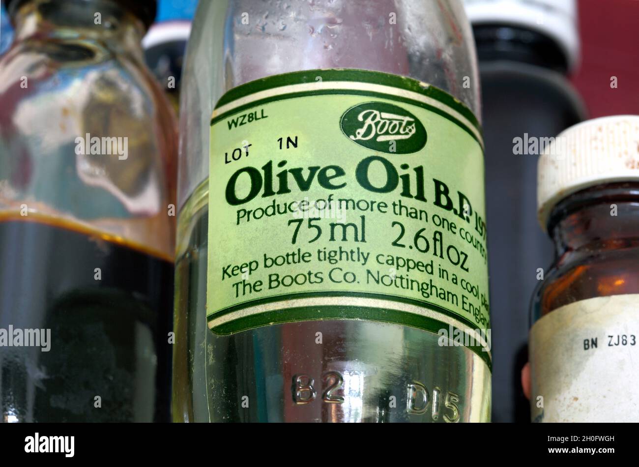 Primer plano de una pequeña botella de aceite de oliva Boots, desde los días en que se vio principalmente como un medicamento que se encuentra en el armario de medicamentos... Foto de stock