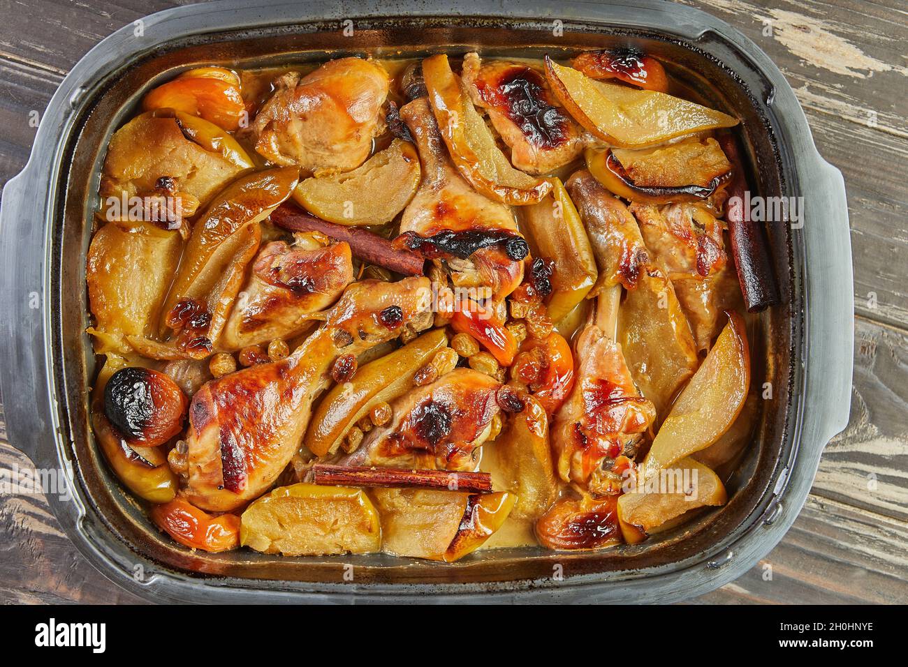 Patas de pollo con miel, pasas, manzanas caramelizadas y peras en el molde  al horno Fotografía de stock - Alamy