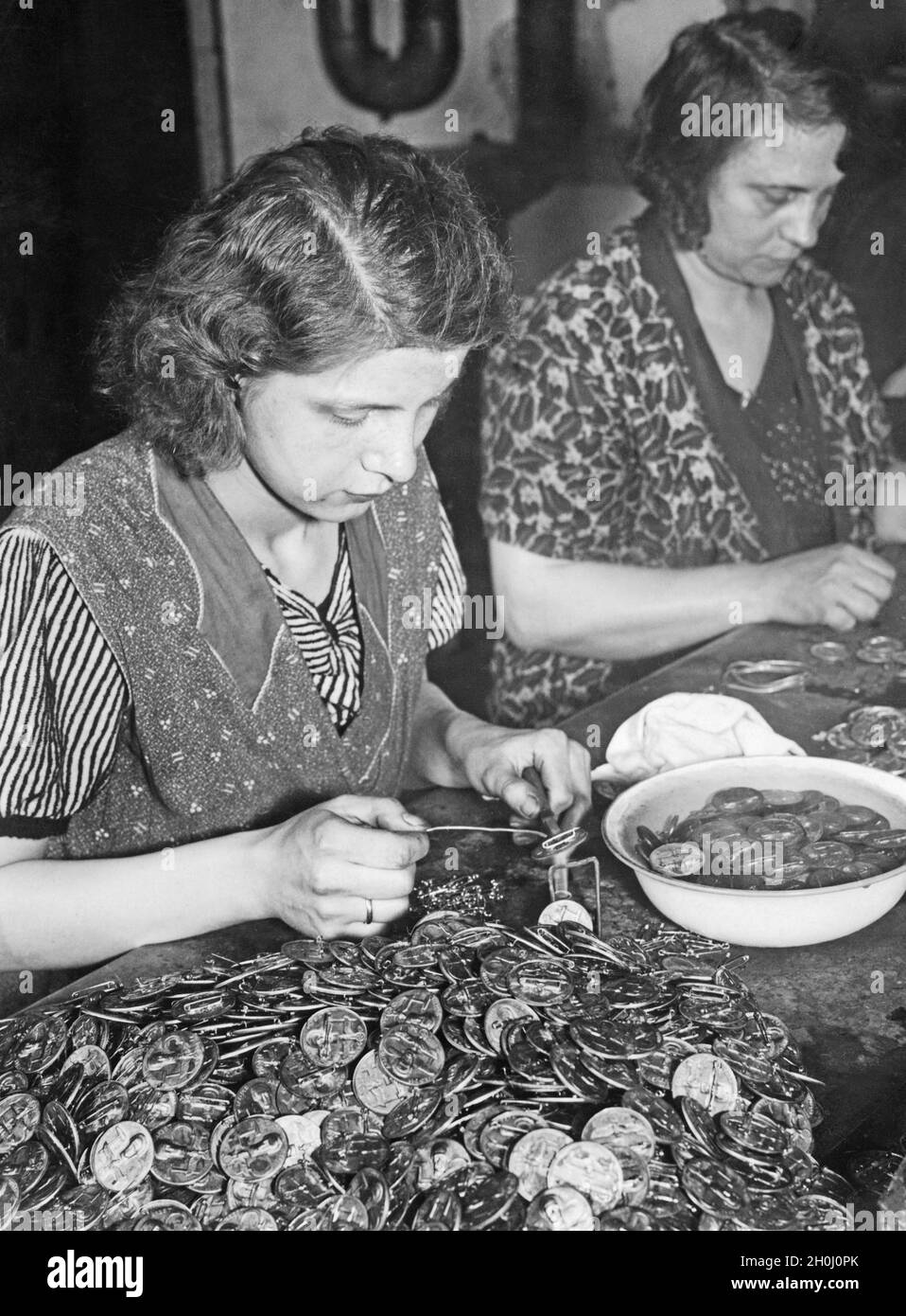 'Las mujeres hacen placas para el ''Día Nacional del Trabajo'' el 1 de mayo de 1934: Soldar en los pines. [traducción automática]' Foto de stock
