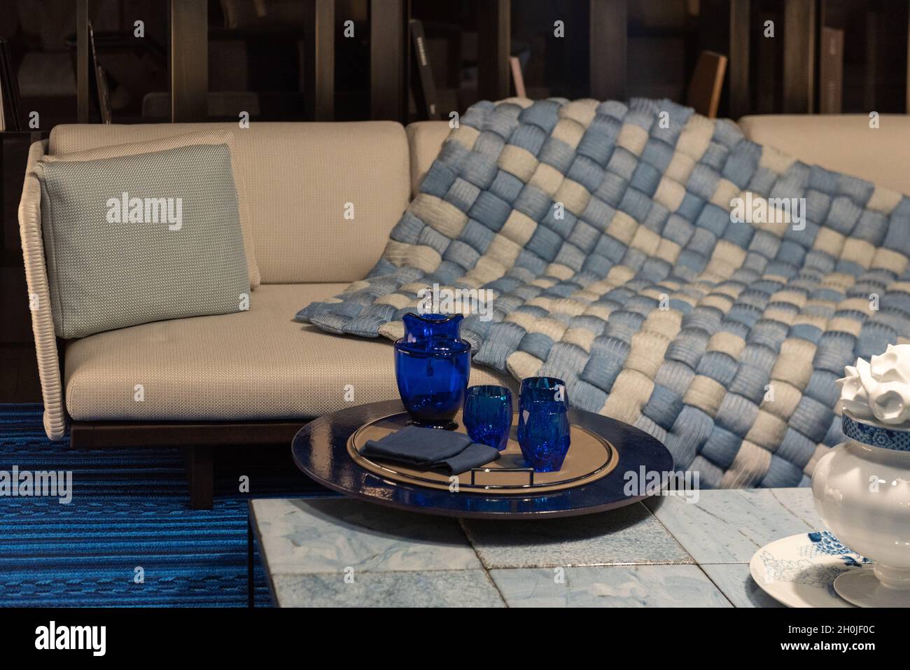 Acogedor salón contemporáneo con elegante sofá, manta suave, mesa de café  con accesorios de decoración Fotografía de stock - Alamy
