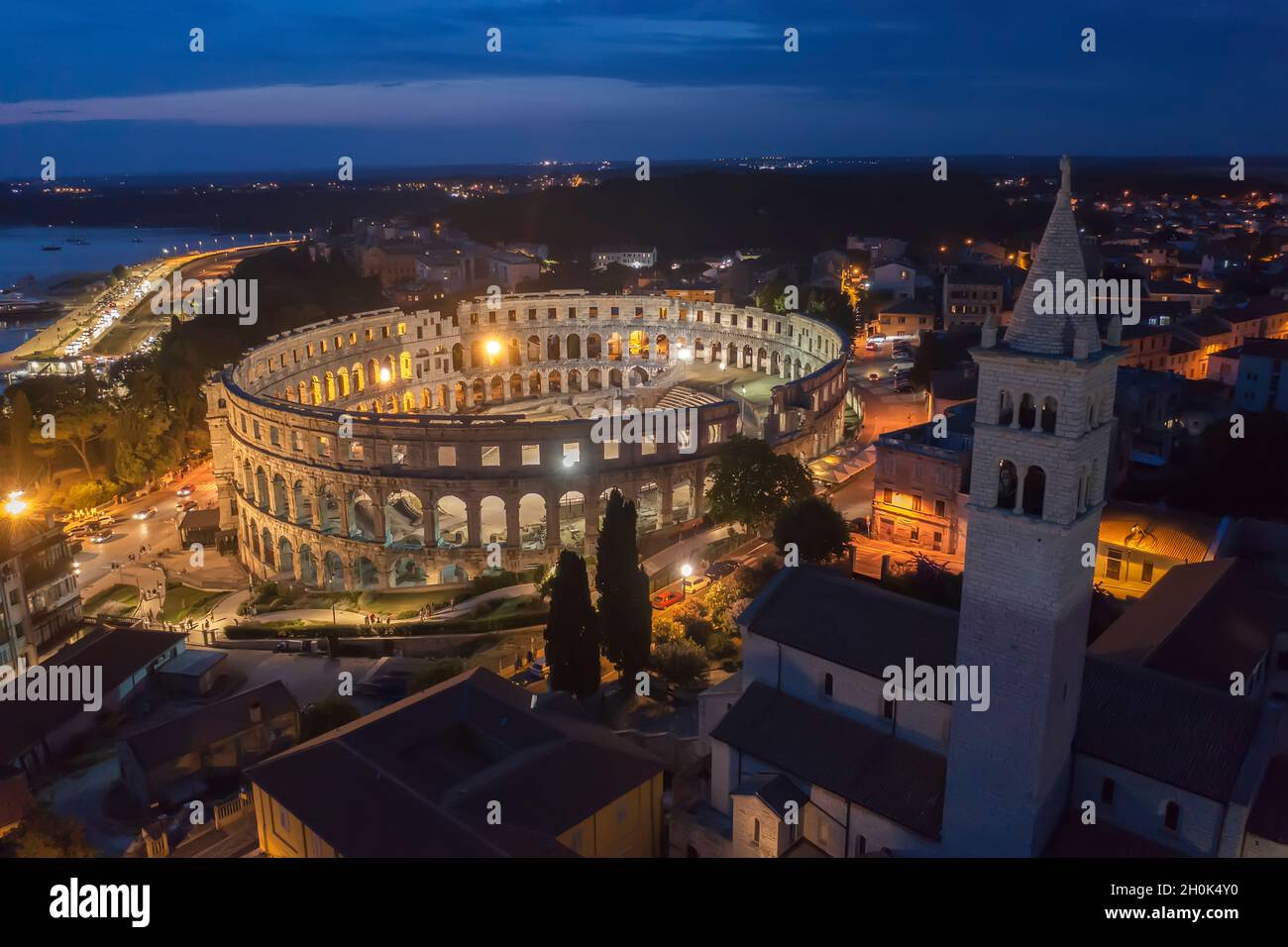 Una vista aérea del aphitheater de Pula por la noche, en el campanario del lado derecho de la iglesia de San Antún, Istria, Croacia Foto de stock
