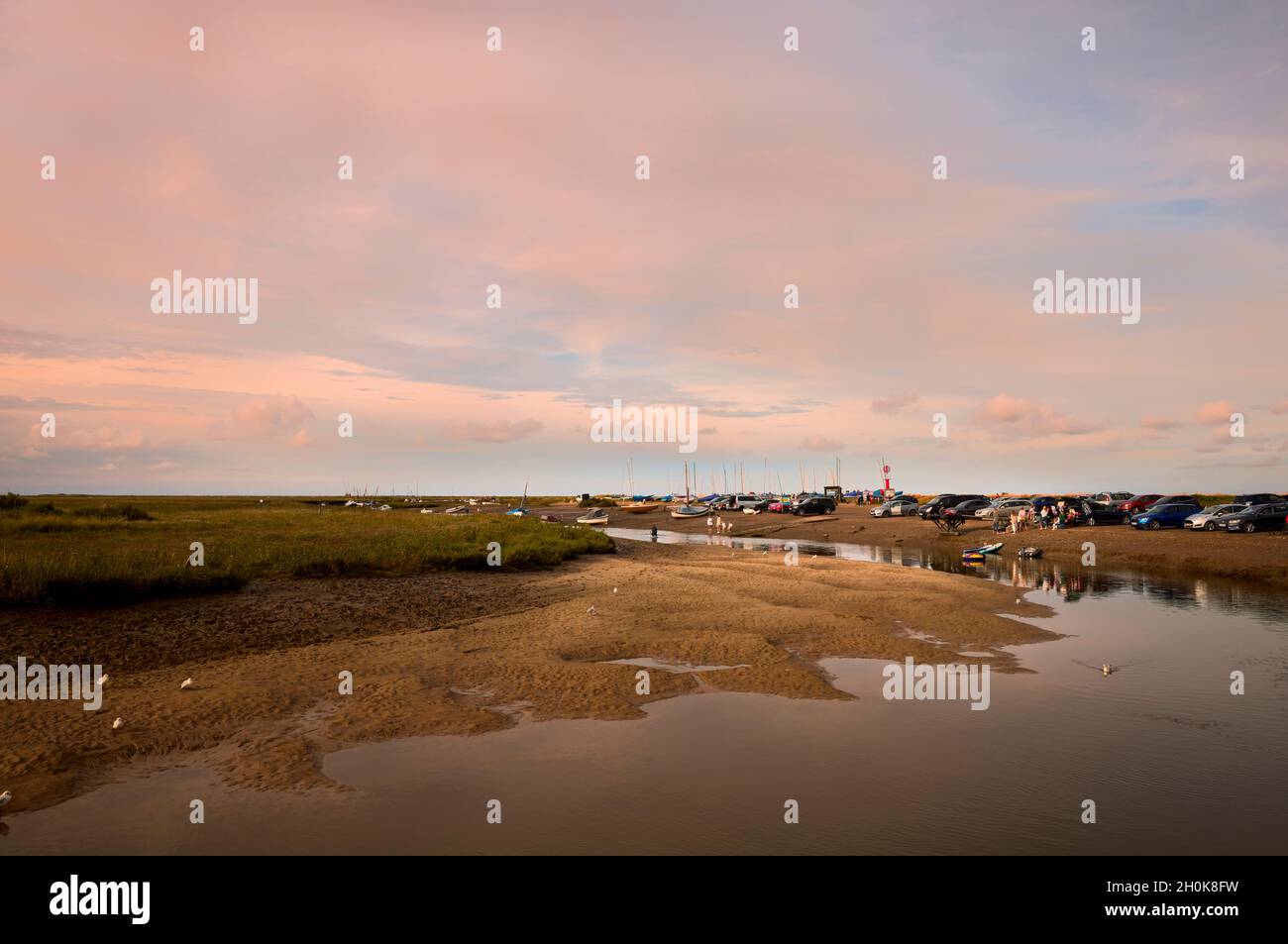 Blakeney y el río Glaven creek en la costa norte de Norfolk, visto desde el muelle en suave luz nocturna con marea baja con un típico cielo grande de Norfolk Foto de stock