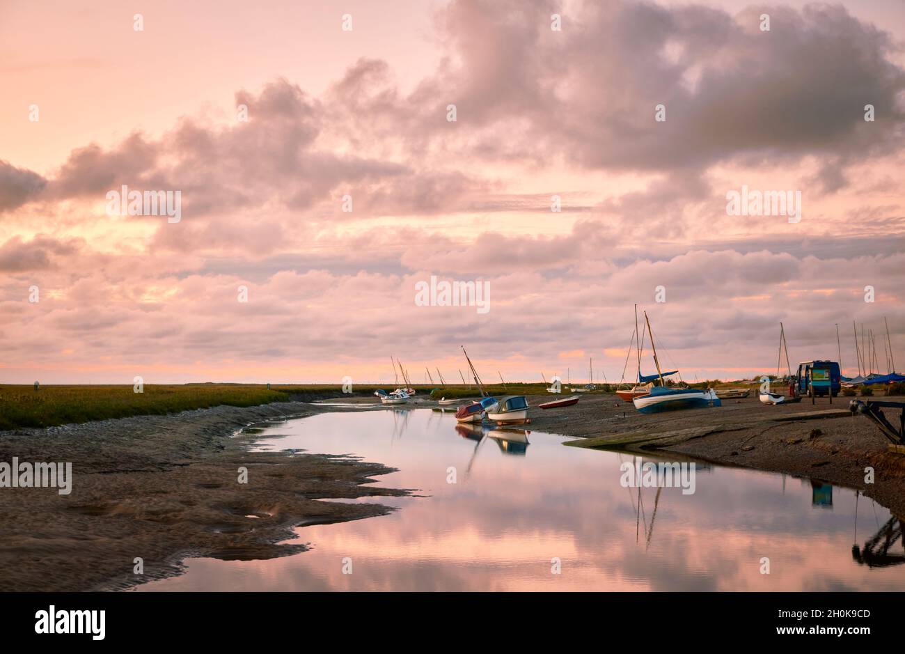 Blakeney y el río Glaven creek en la costa norte de Norfolk, visto desde el muelle en suave luz nocturna con marea baja con un típico cielo grande de Norfolk Foto de stock