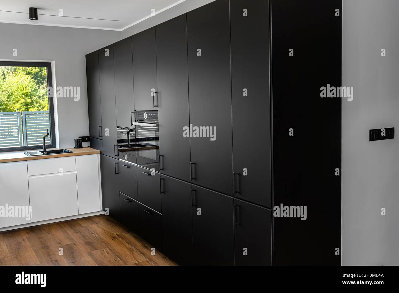 Cocina moderna con frontales negros, horno y microondas, paneles de vinilo  en el suelo Fotografía de stock - Alamy