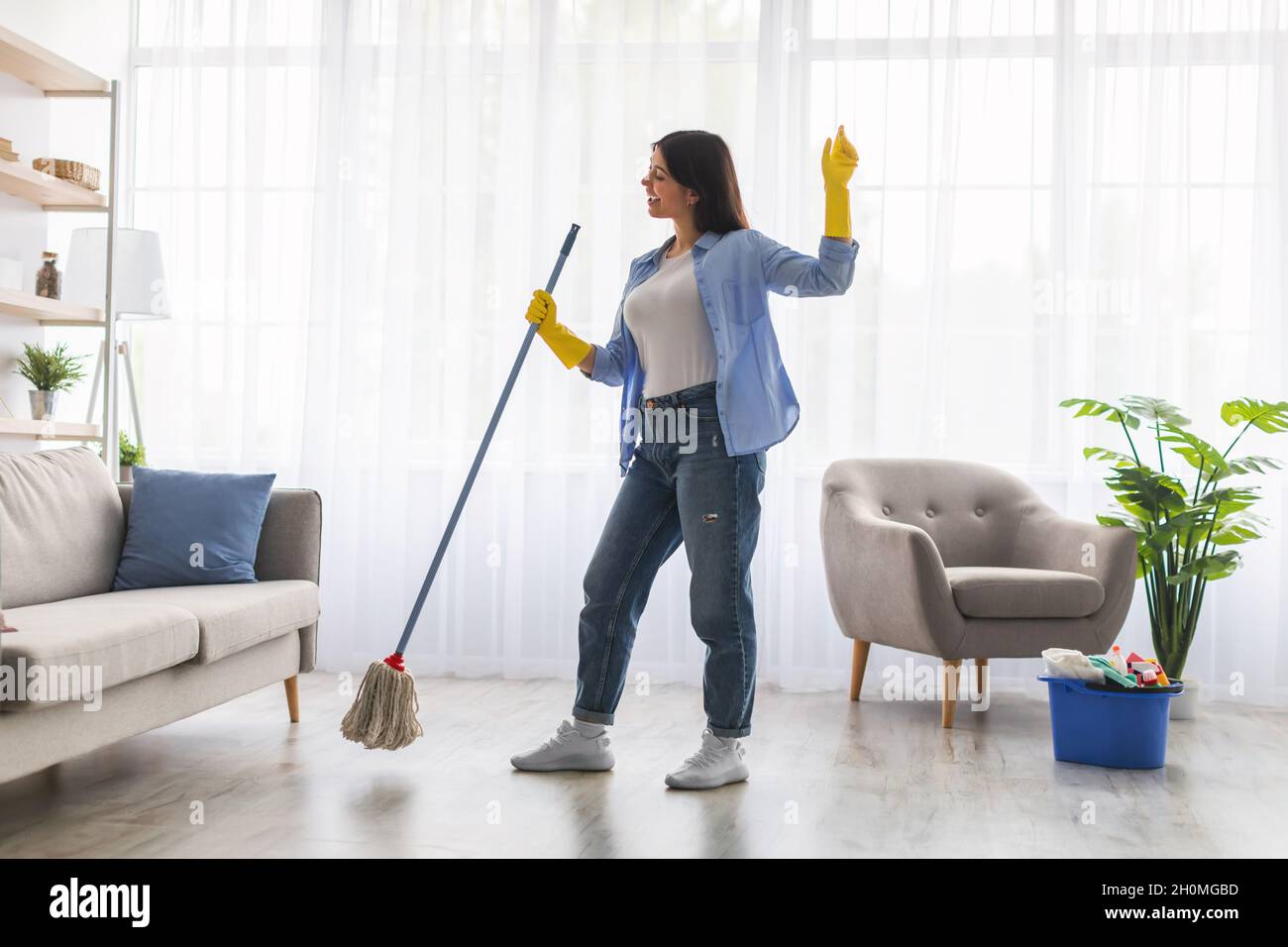 Pareja disfrutando de la limpieza de su casa con aspiradora y fregona  Fotografía de stock - Alamy