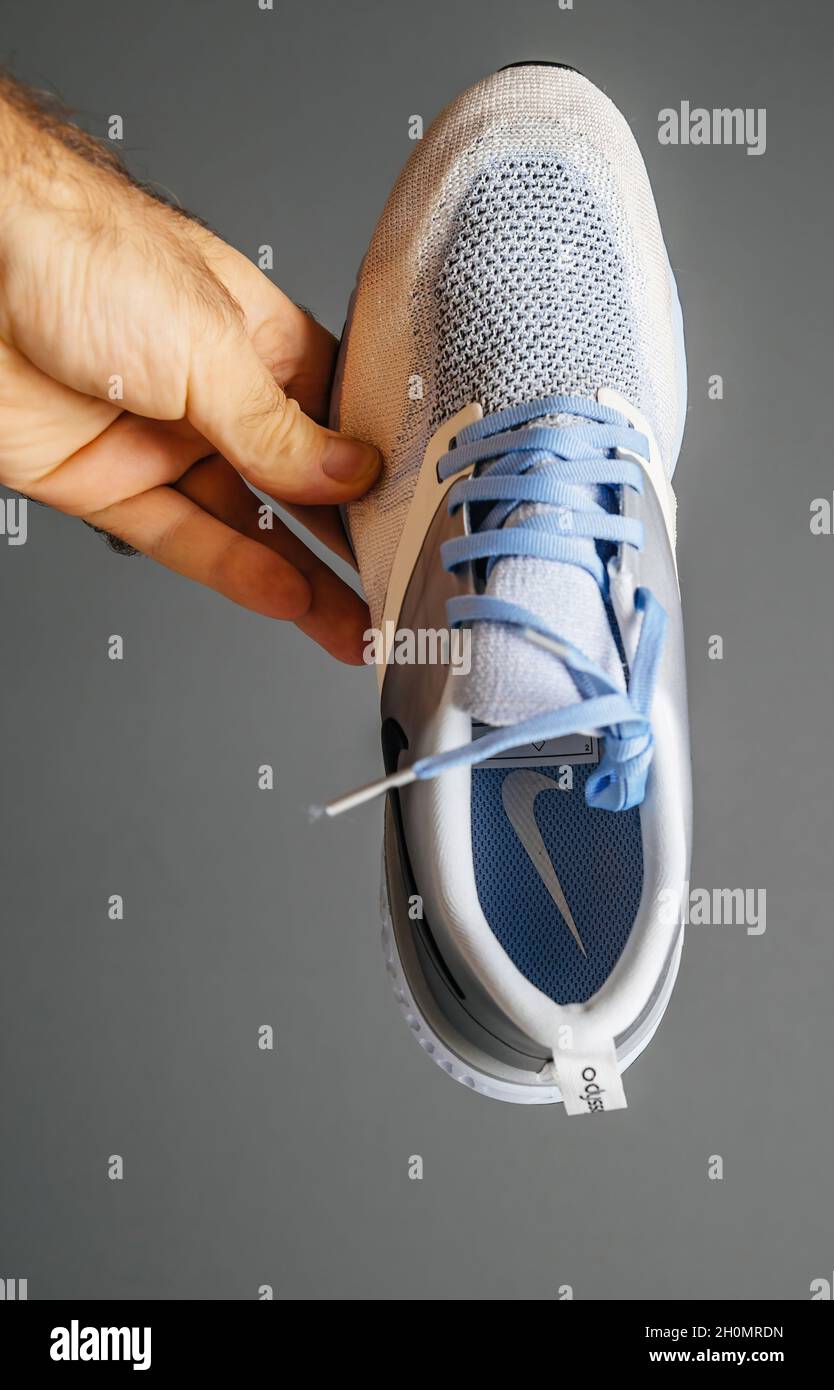 POV macho con la mano sosteniendo nuevas zapatillas de running con logotipo  de Nike en la suela Fotografía de stock - Alamy
