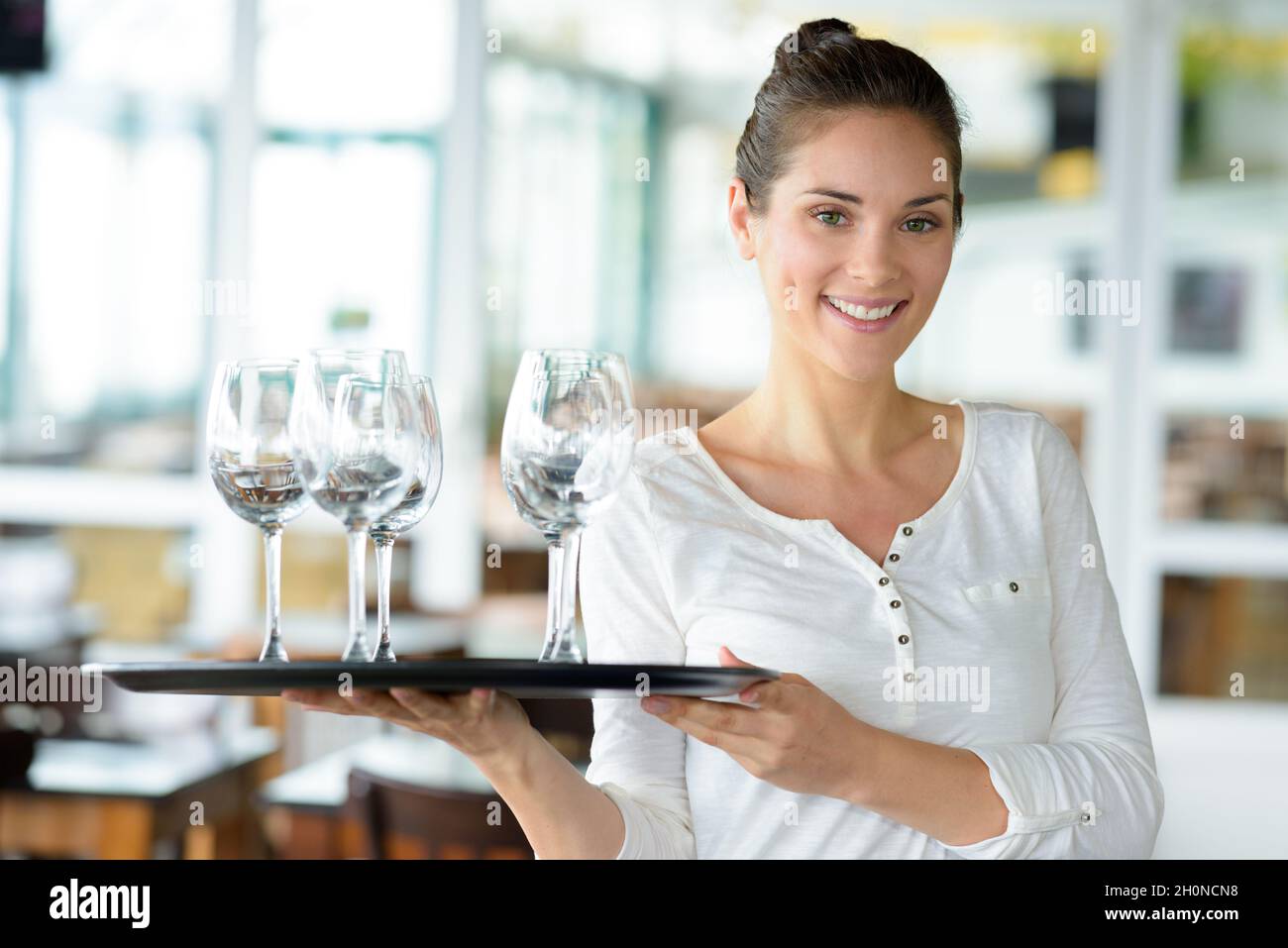 una hermosa chica-camarero se lleva una bandeja con vasos Fotografía de  stock - Alamy