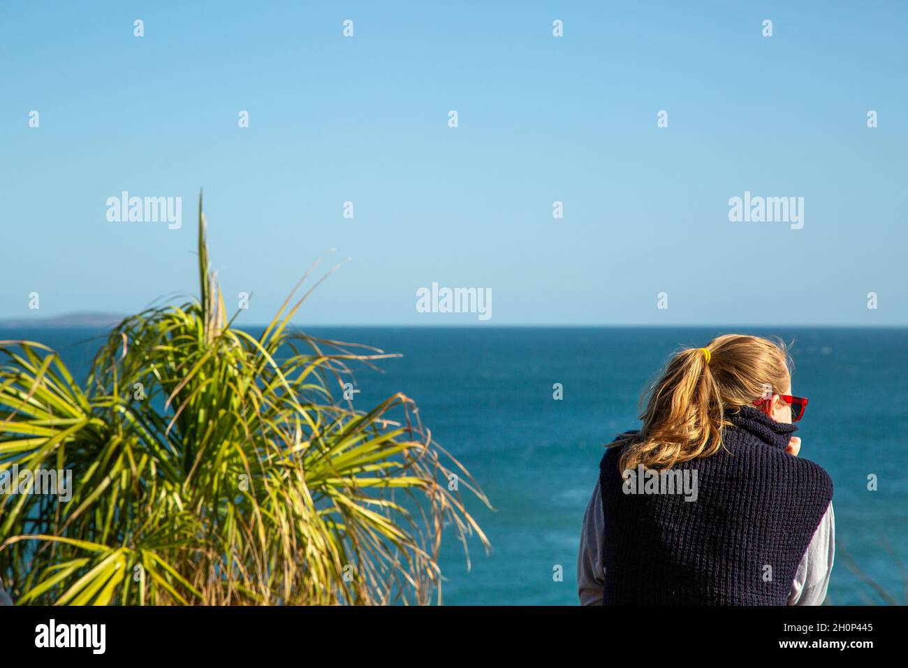 Una señora de pelo justo reflexionando sobre el océano. Foto de stock
