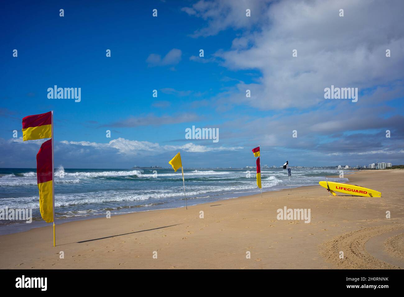 Salvavidas, tablas de surf y banderas de advertencia en la playa, Mudjimba Beach, Queensland, Australia Foto de stock