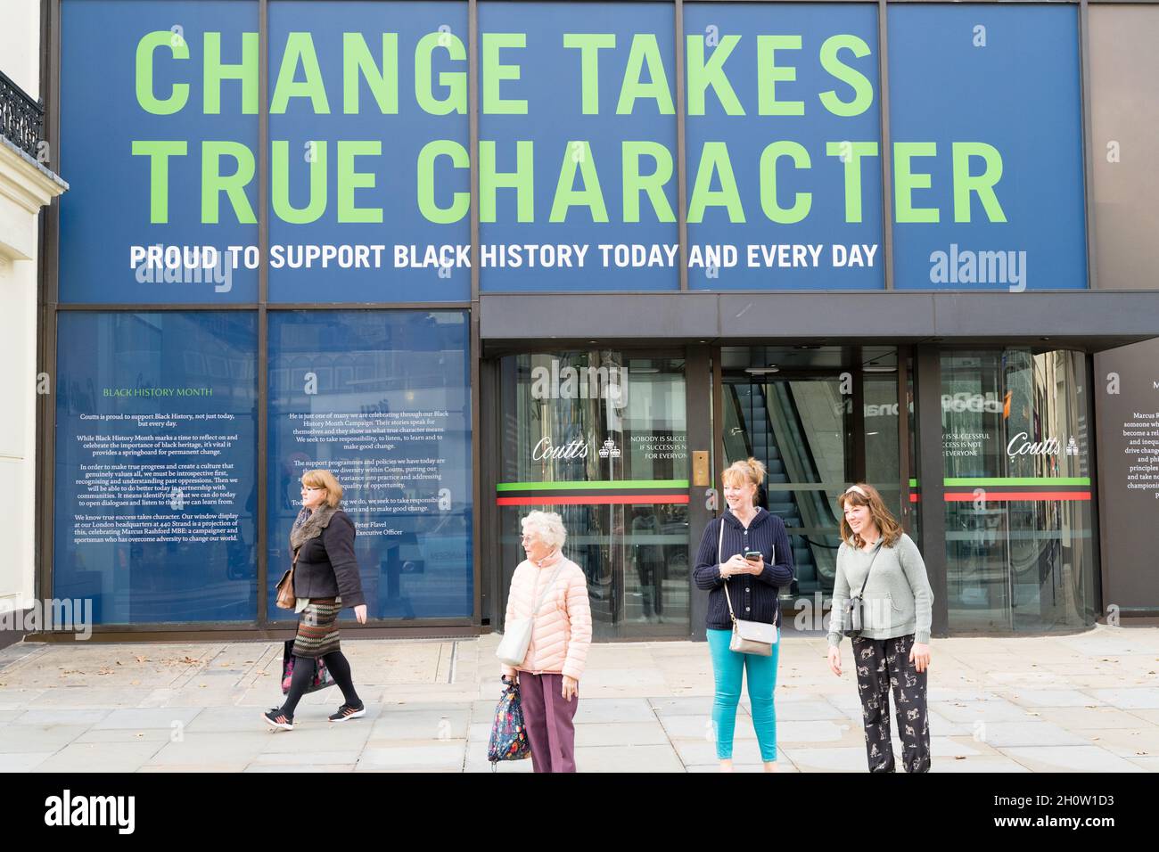 Change toma los verdaderos personajes mostrados en la pared delantera del banco privado Coutts en The Strand , grupo de mujeres charlando fuera de la entrada, Londres Engla Foto de stock