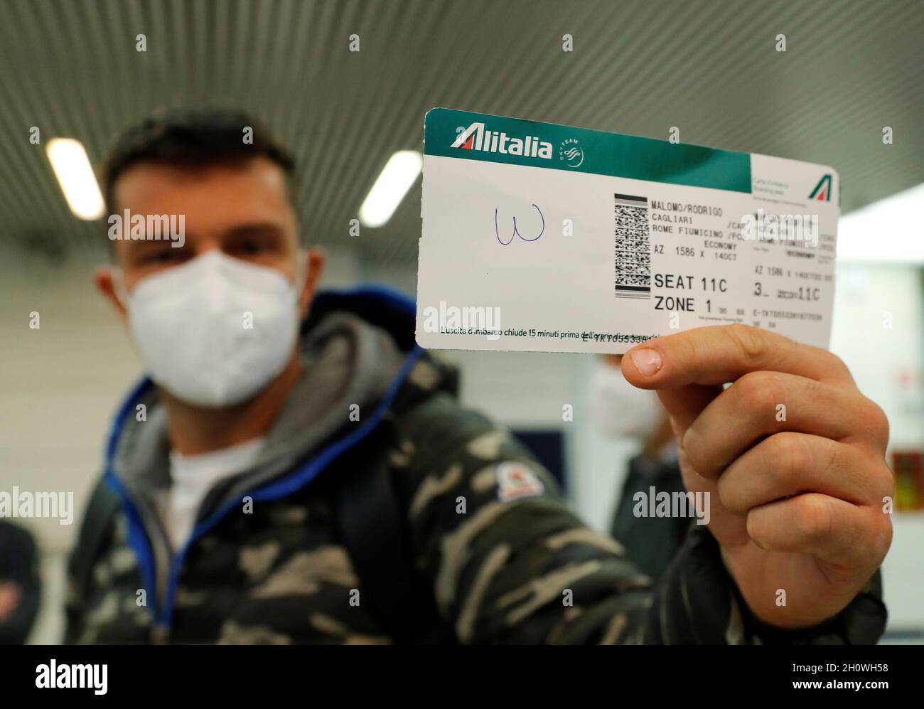 Un pasajero retiene el billete del último vuelo de Alitalia número AZ1586  desde Cagliari después de que el avión aterrizara en el aeropuerto  Fiumicino de Roma, en la víspera de la toma