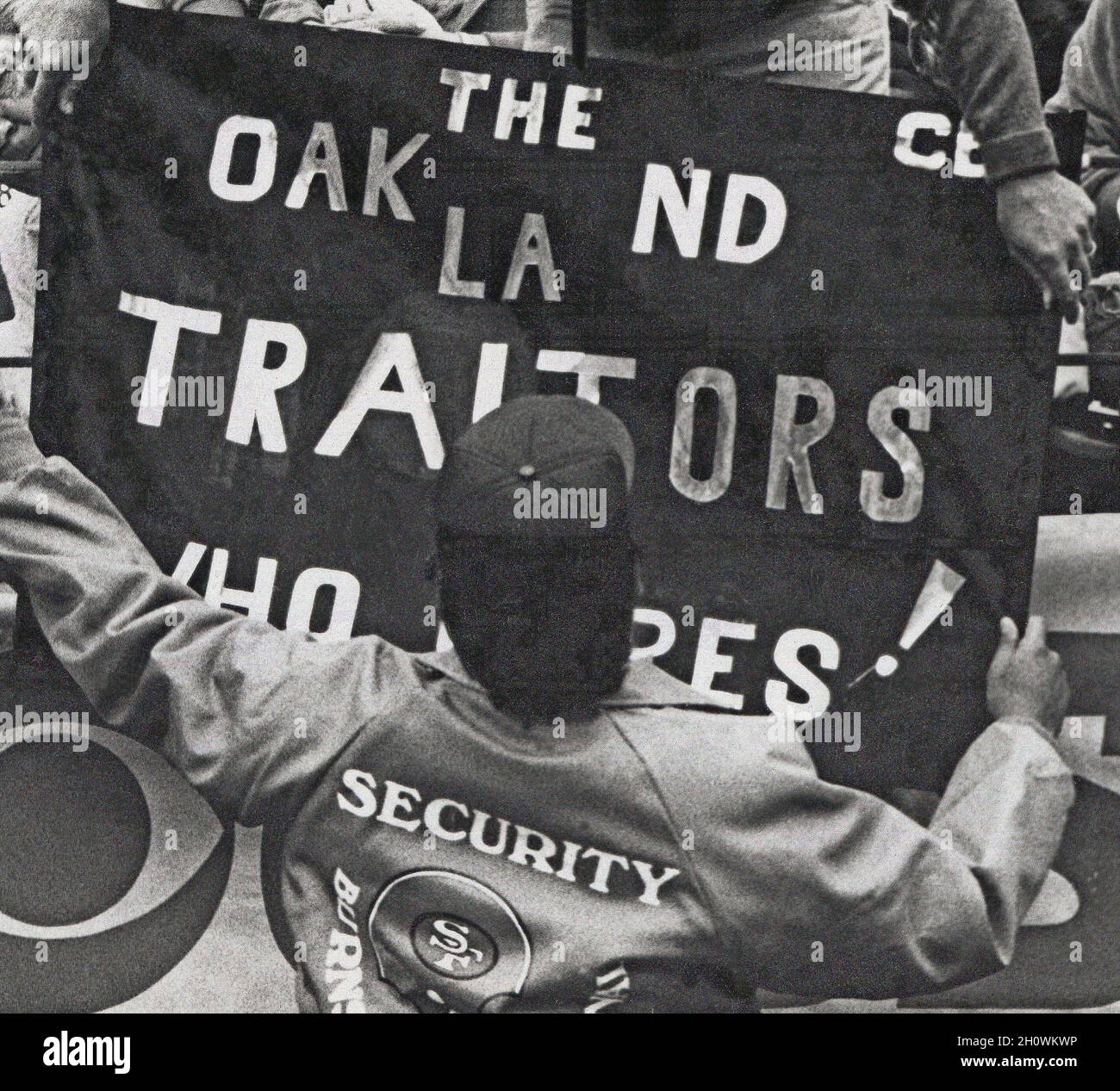 San Francisco 49ers, persona de seguridad del equipo de fútbol durante un partido contra los Raiders en el Candlestick Park de San Francisco quitando la bandera 'Oakland Traitors' después de que los Raiders se trasladaran de Oakland a Los Angeles, California, 1980s Foto de stock