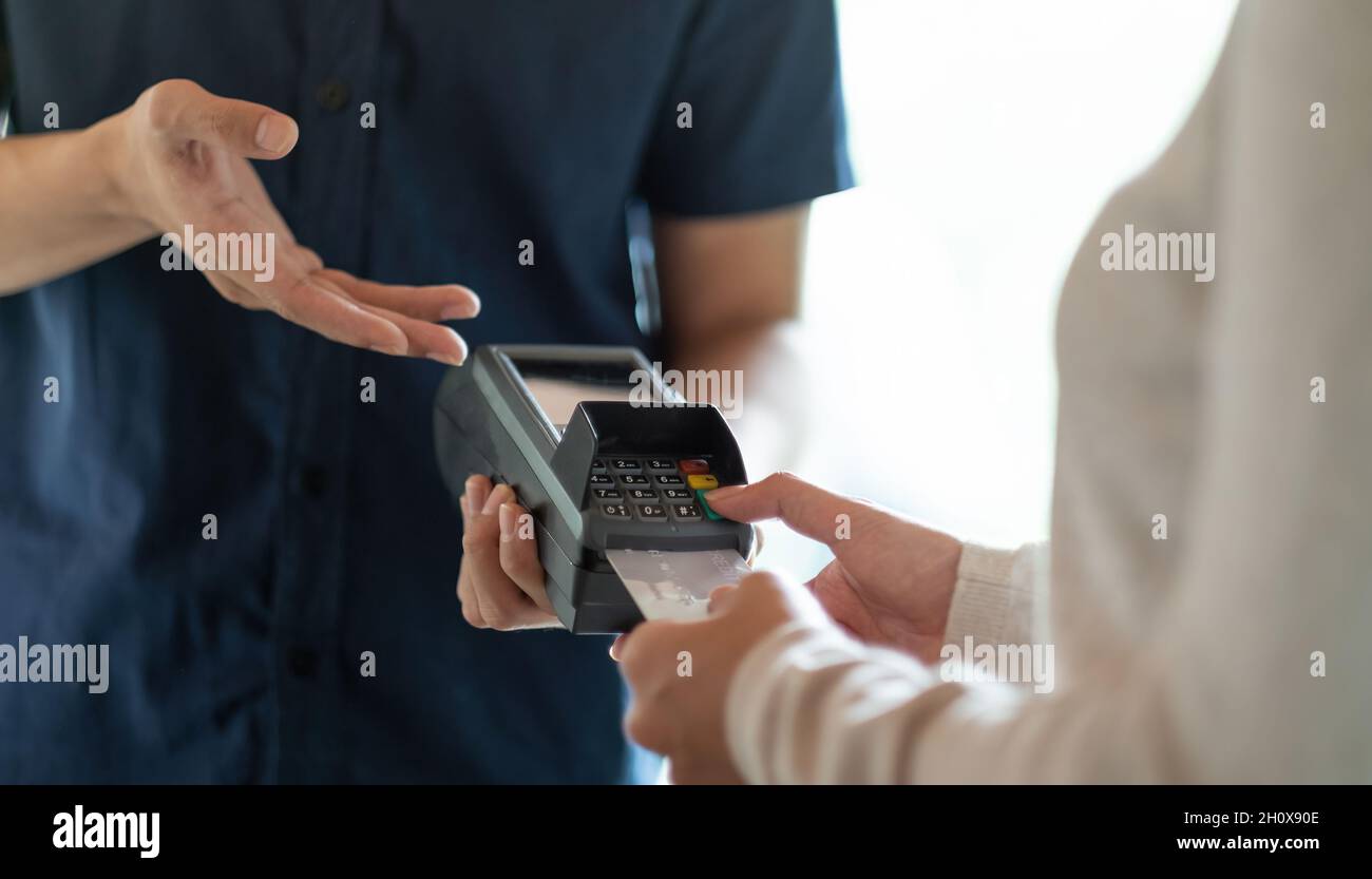 Cliente que utiliza tarjeta de crédito para el pago al propietario en el restaurante cafetería Foto de stock