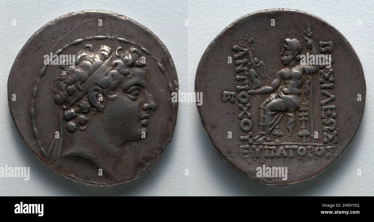 Tetradrachm: Antiocho V (anverso); Zeus (reverso), 164–162 aC. Griego, Seleukid, acuñado en Antioquía (Siria), reinado de Antiochos V. Plata; diámetro: 3,1 cm (1 1/4 in.). Empujada al poder mientras todavía era un niño, Antiocho V usó la acuñación para legitimar su tenue control. En el anverso de esta moneda, Antiocho aparece como muchos reyes helenísticos, con rizos de pelo pesado y un diadema. Al revés, un Zeus sentado sostiene a la diosa de la victoria, Nike, que corona el nombre de Antiocho con una corona, confirmando su derecho divino a gobernar. Foto de stock