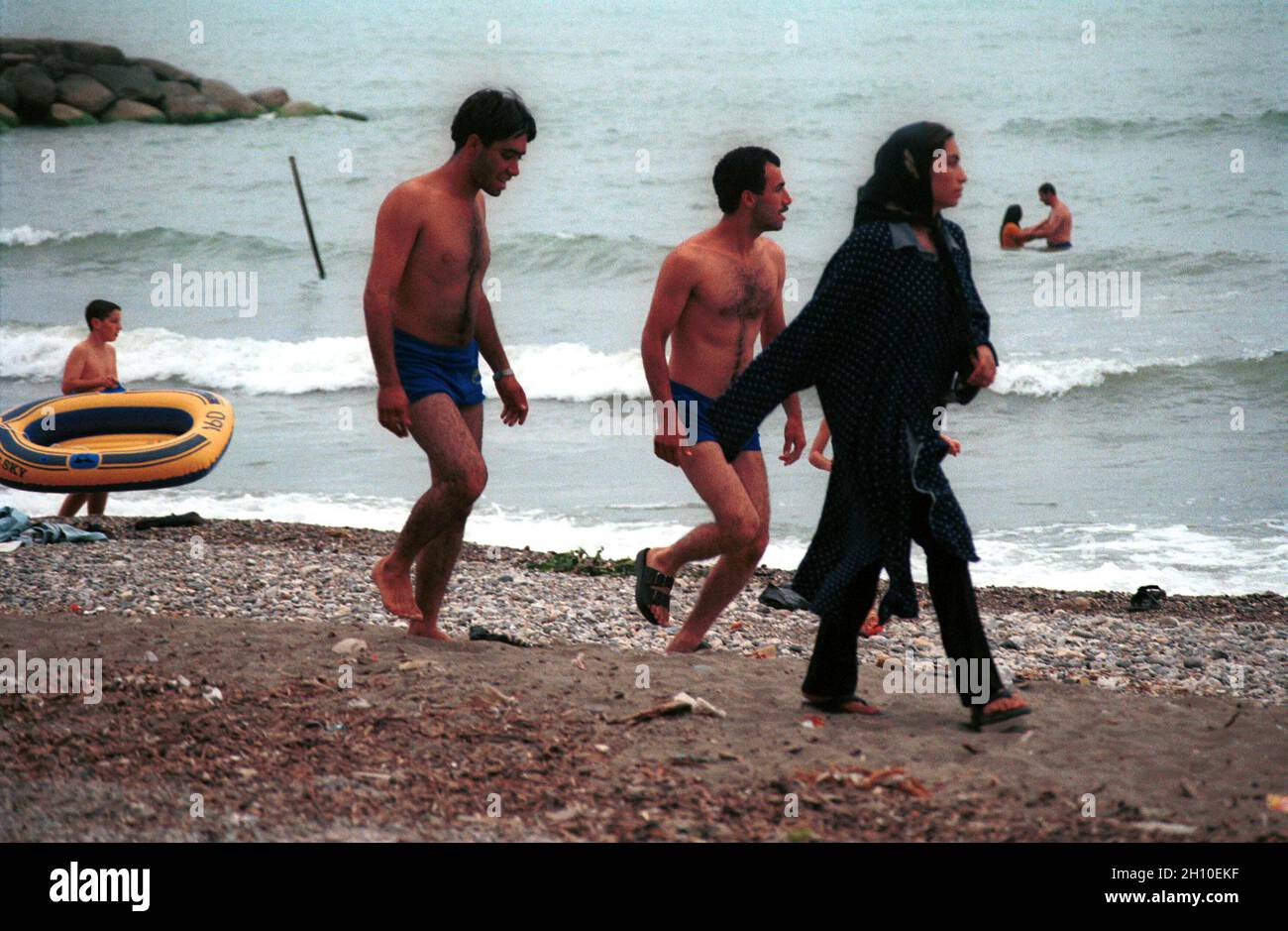 Una niña iraní caminando en el banco Caspio. La natación sin ropa está prohibida para las mujeres iraníes, causa de las normas islámicas Fotografía de stock -