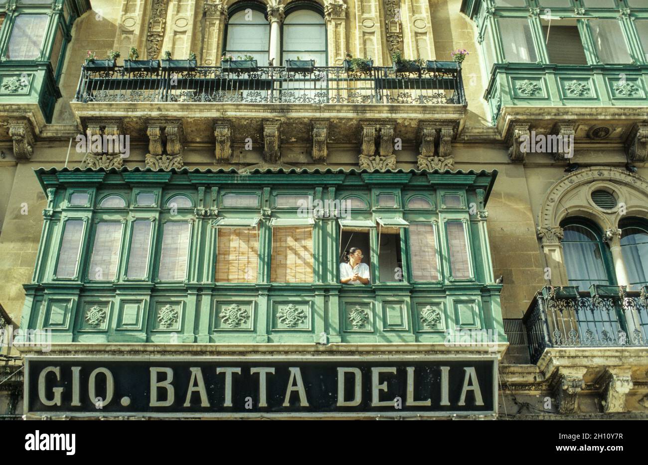 Frau am Fenster: Ein für Malta typischer Erker an einem Haus in der Altstadt von Valetta - Mujeres en la ventana: Un típico mirador de Malta en un edificio en el casco antiguo de Valetta. Foto de stock