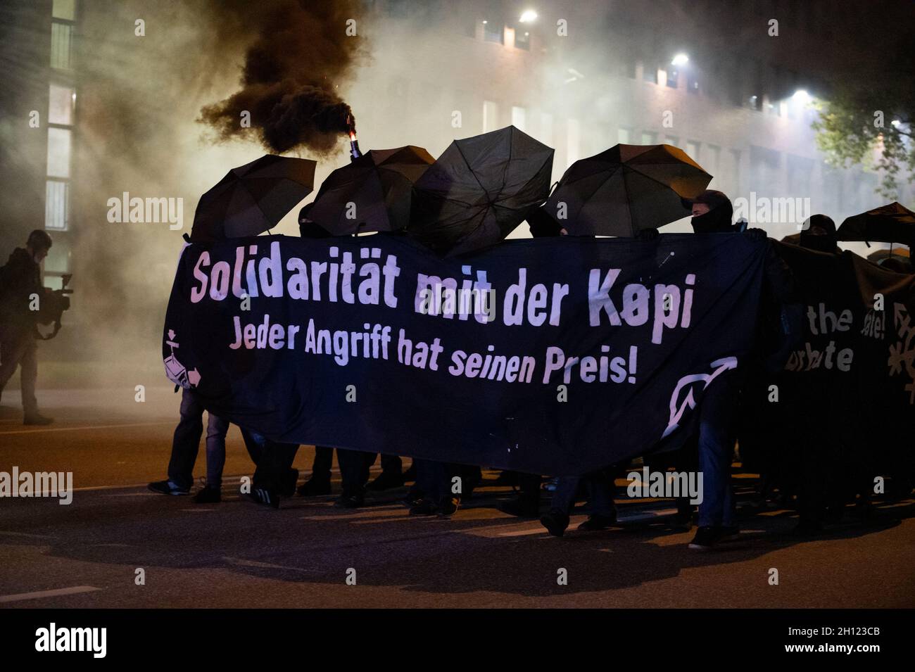 Hamburgo, Alemania. 15th Oct, 2021. 'Solidaridad con los Köpi - cada ataque  tiene su precio' está escrito en una pancarta detrás de la cual los  manifestantes despedían pirotecnia. En protesta contra el