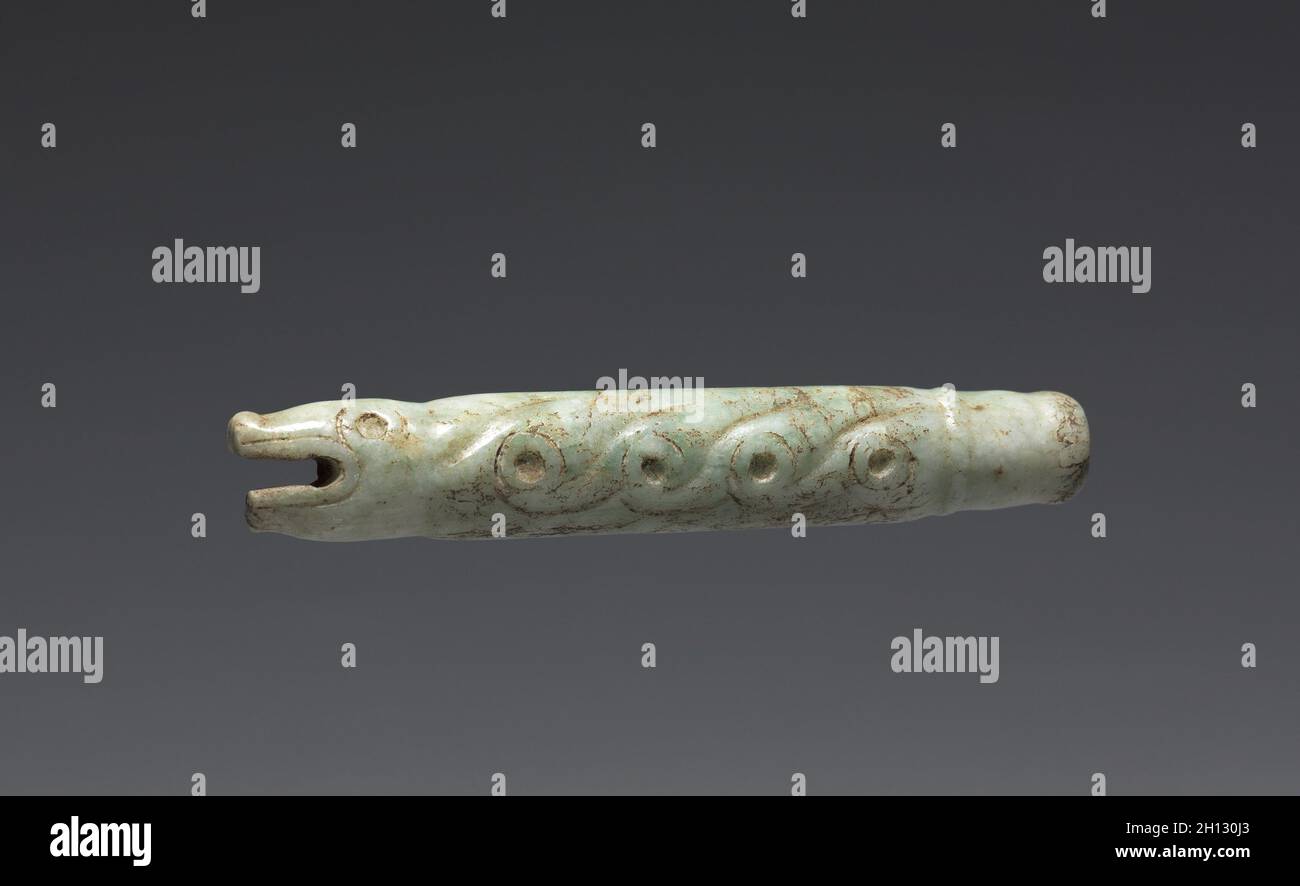 Asa del ventilador de forma serpiente(?), 900-1519. La parte central de México, mixteco. Jade verde pálido; Diámetro: 1,9 cm (3/4 pulg.); total: 10,5 x 2 cm (4 1/8 x 13/16 in.). Foto de stock