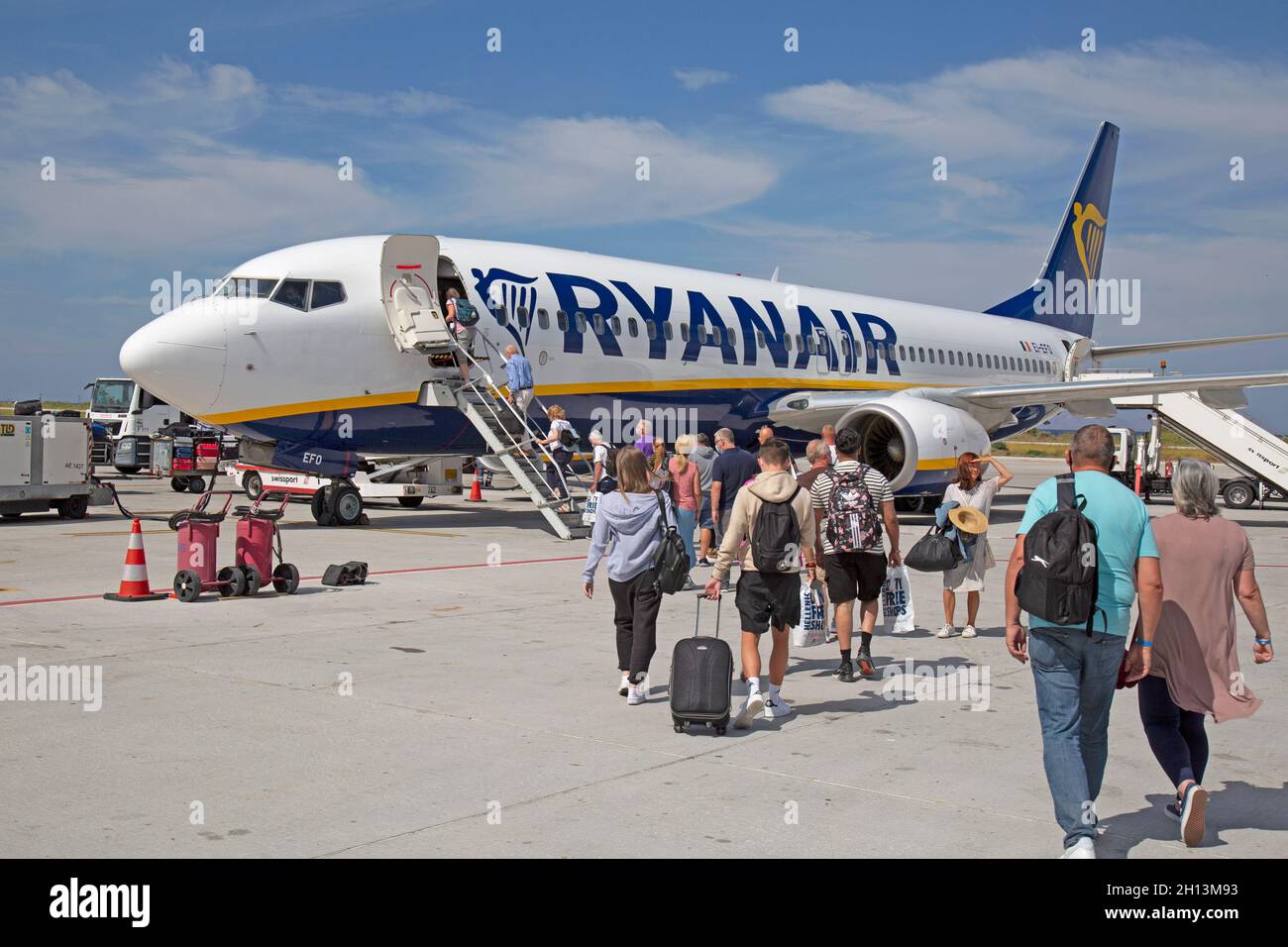 Pasajeros caminando hacia las escaleras a punto de subir a bordo de un avión de pasajeros Ryanair Boeing 737-800 en el aeropuerto de Rodas, Grecia. Foto de stock