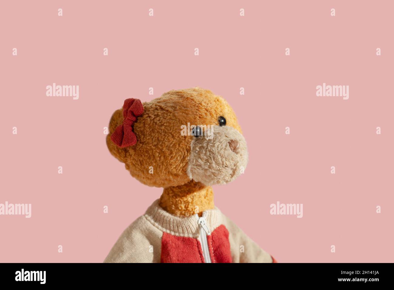Retrato de niña vintage osito de peluche mirando hacia arriba, soñando.  Arco rojo. Aislado sobre fondo rosa claro. Espacio vacío para texto  Fotografía de stock - Alamy
