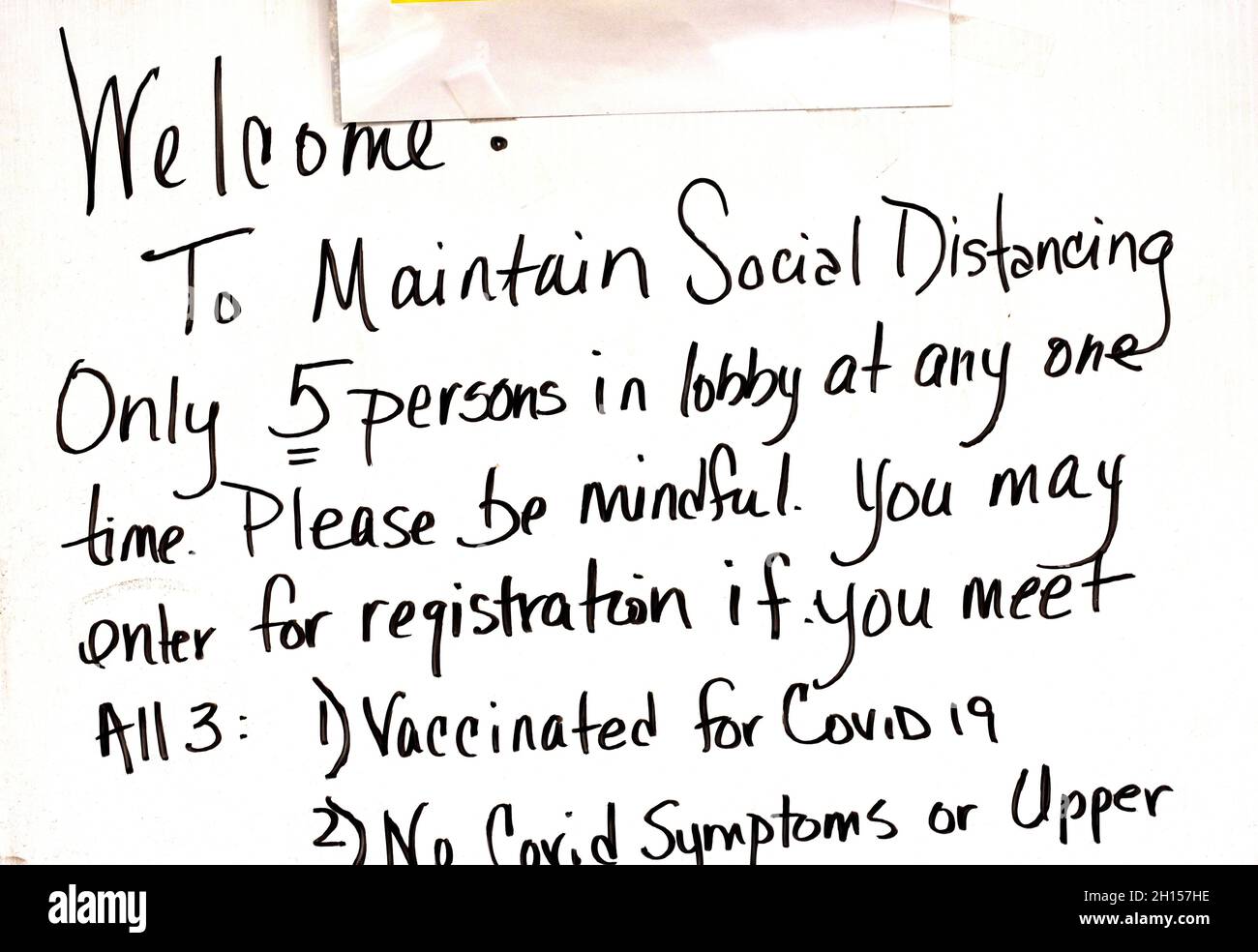 Un cartel en la entrada de una clínica de atención urgente informa a los visitantes que deben mantener el distanciamiento social dentro del edificio debido a Covid-19. Foto de stock