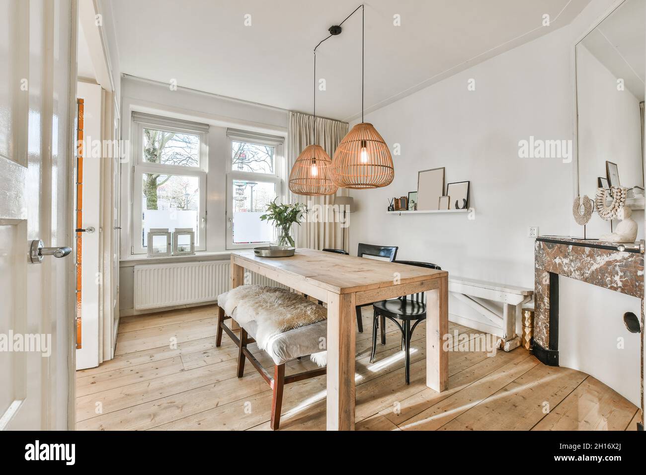 Diseño creativo del comedor con banco y mesa de madera bajo lámparas que  cuelgan contra la ventana de la casa Fotografía de stock - Alamy