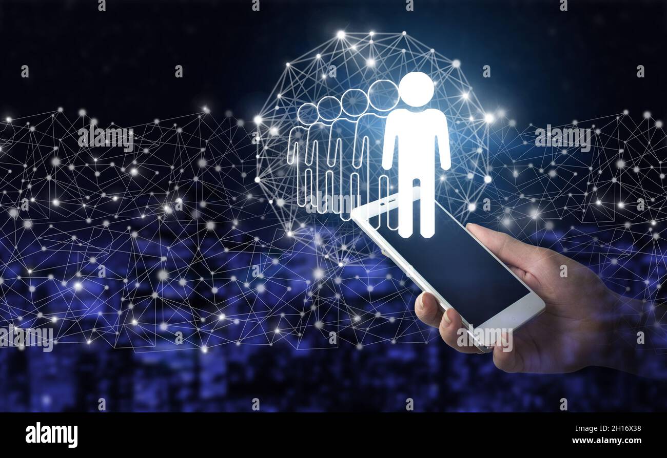 Recursos Humanos Empleo de Reclutamiento. Smartphone blanco con holograma digital humano, signo de líder en la ciudad fondo oscuro y borroso. Busine Foto de stock