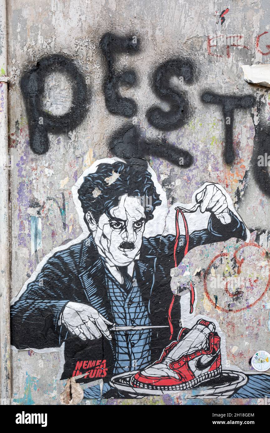 Charlie Chaplin comiendo zapatillas Nike. Cartel de arte callejero de pasta  para cortar a la forma en el distrito Trastevere de Roma, Italia Fotografía  de stock - Alamy