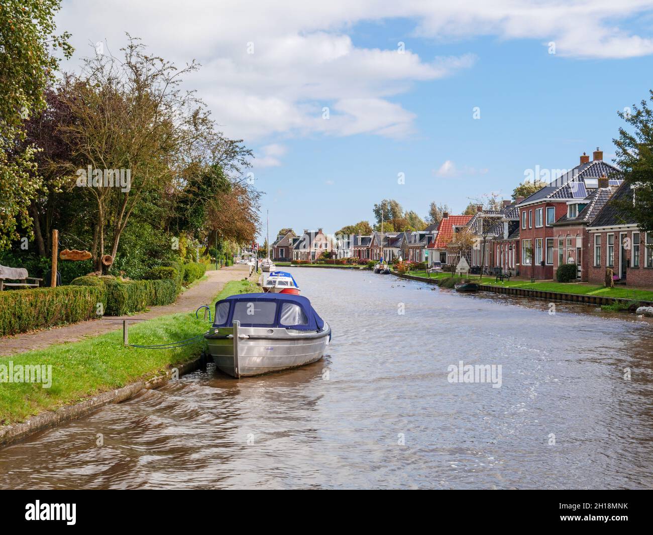 Dokkumer EE canal con casas y barcos en el casco antiguo de Birdaard en Frisia, Holanda Foto de stock