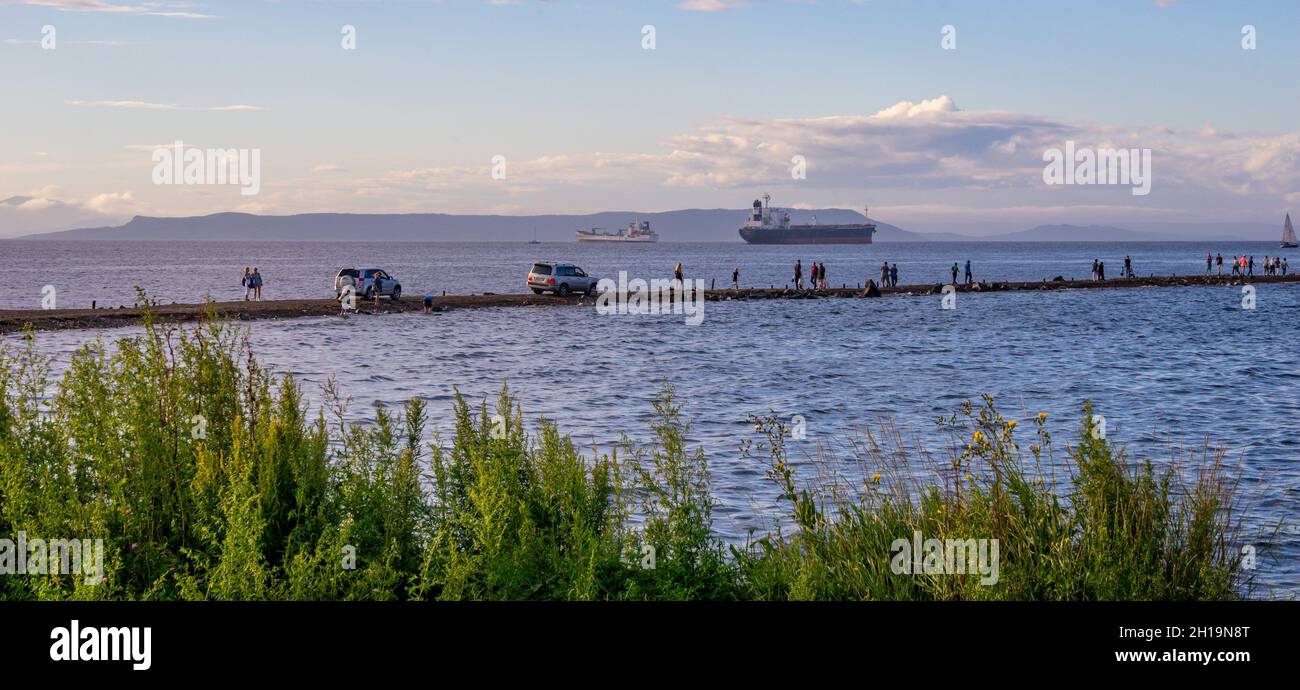 Vladivostok, Rusia - 26 de agosto de 2018: Paisaje marino con una vista de la Kosa Tokarevskaya con personas y coches Foto de stock