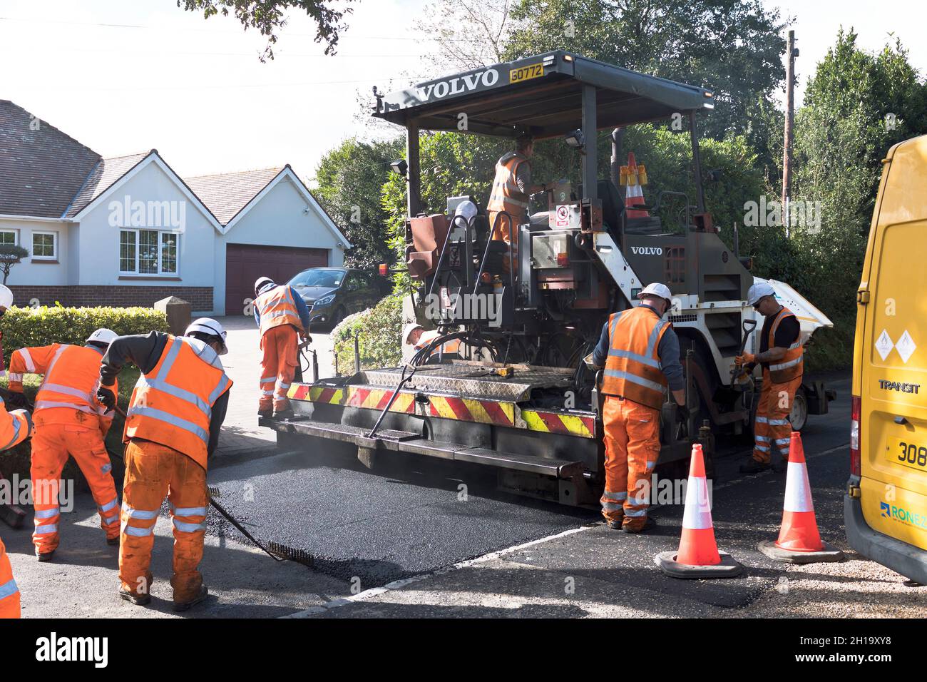 dh TARMACING ROAD Reino Unido Trabajadores de la máquina que ponen asfalto carretera Tar Mac superficie Foto de stock