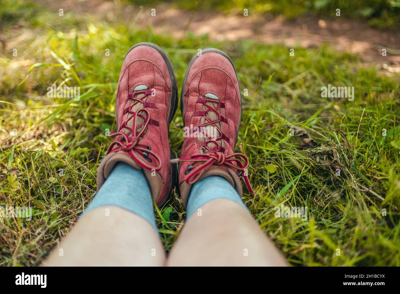 Relaje a la mujer viajera en botas de trekking tumbada sobre hierba verde  en la cima de la colina disfrutando Fotografía de stock - Alamy