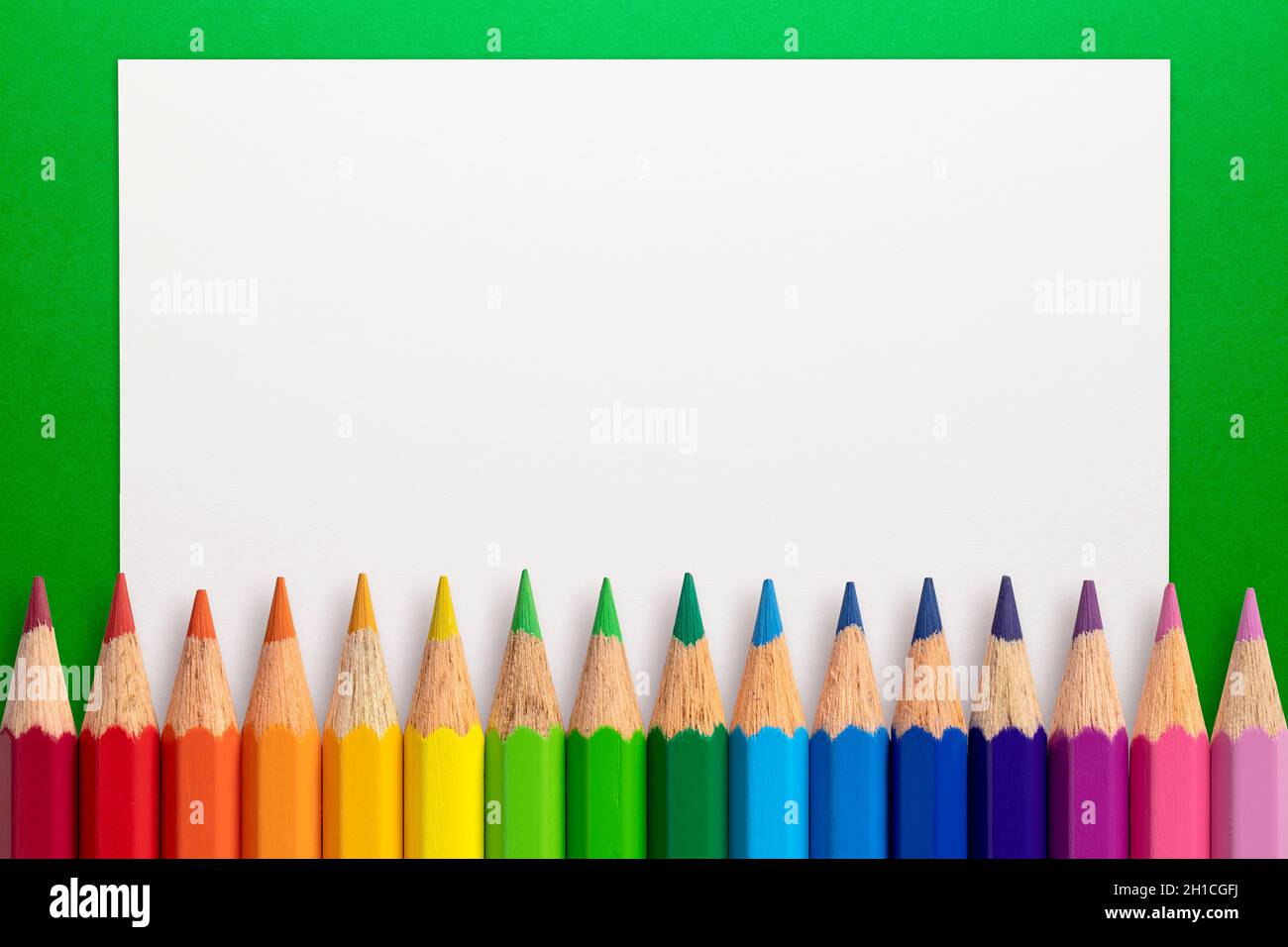 Marco de lápices de colores y papel blanco sobre fondo verde Fotografía de  stock - Alamy