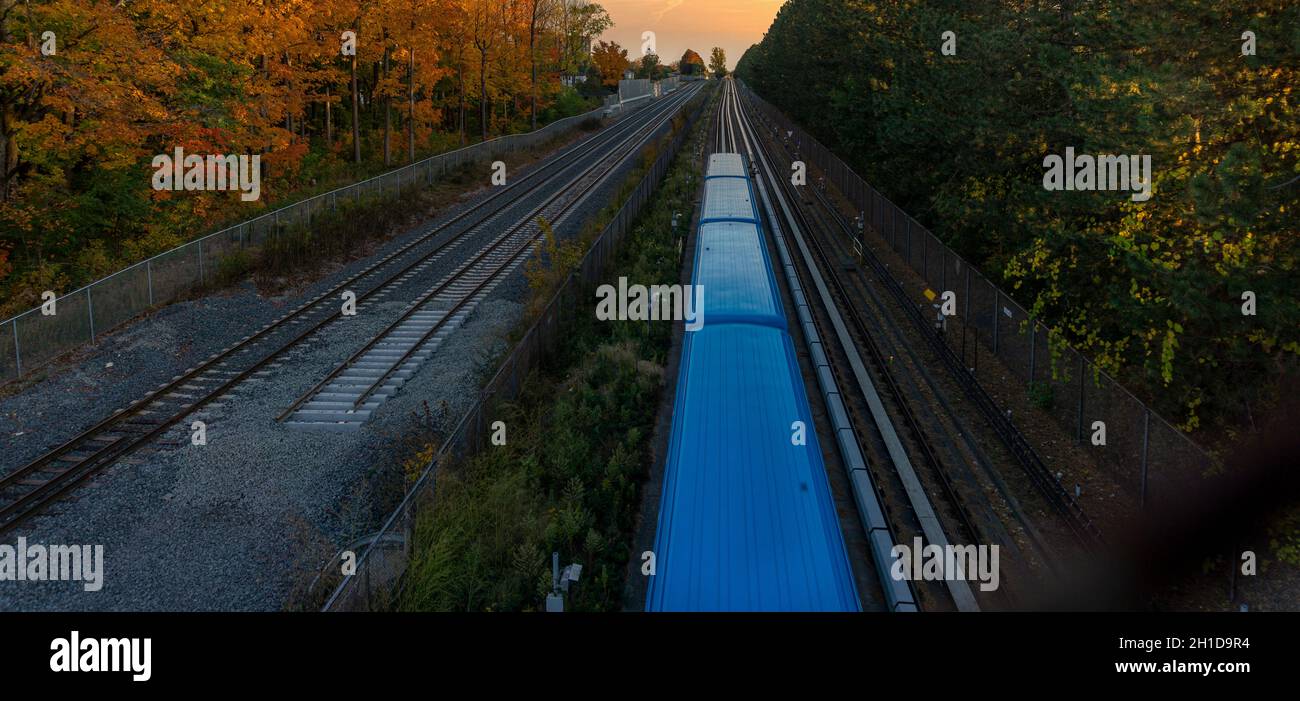 Vista desde arriba de un tren azul que atraviesa el campo durante la temporada de otoño. Hermoso paisaje otoñal Foto de stock