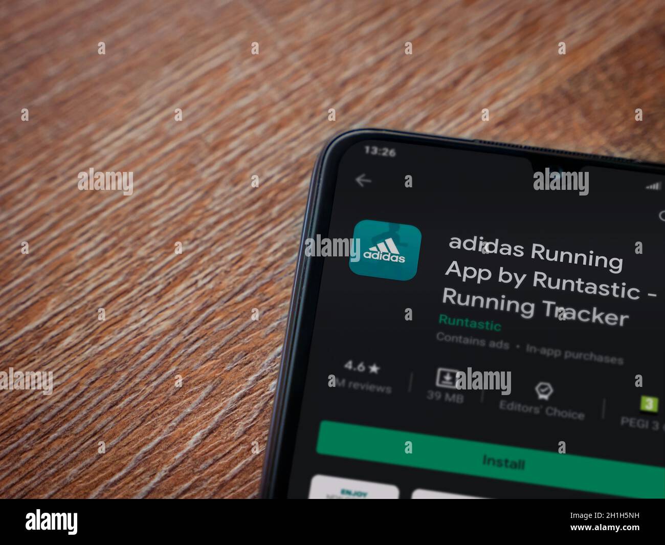 LOD, Israel - 8 de julio de 2020: Adidas running app play store page en la  pantalla de un smartphone móvil negro sobre fondo de madera. Vista superior  plano de la cama