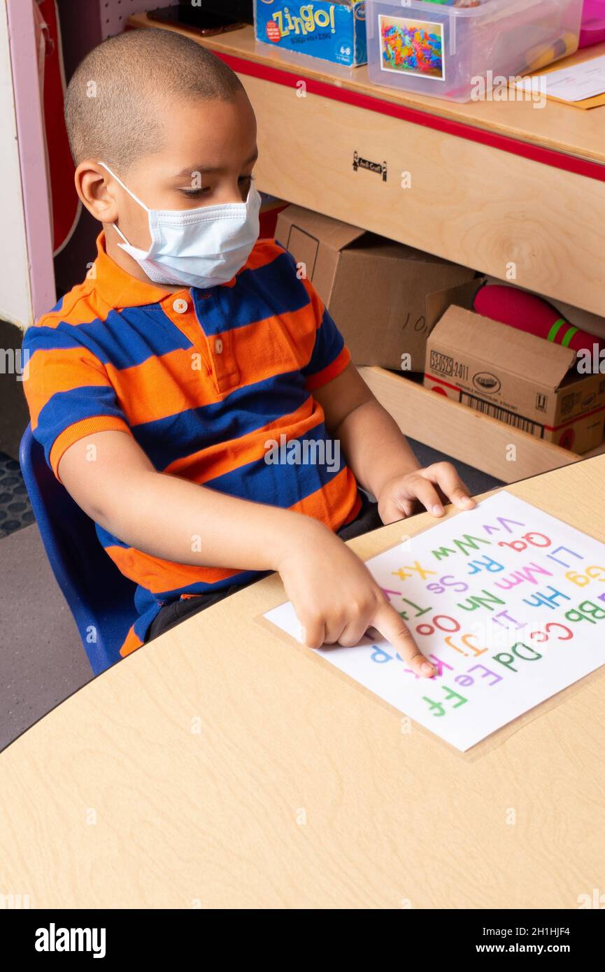 Educación Preescolar Niño de 4-5 años apuntando a la letra en el rompecabezas del alfabeto Foto de stock