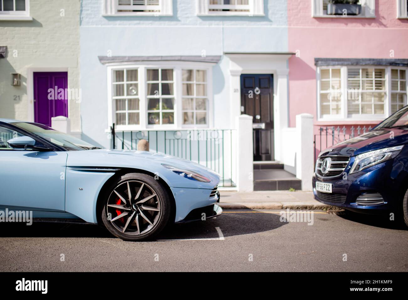 Londres, Reino Unido - 30 de septiembre de 2020: Imagen del lado lateral de un automóvil deportivo azul claro estacionado fuera de una casa azul desde un barrio británico Foto de stock